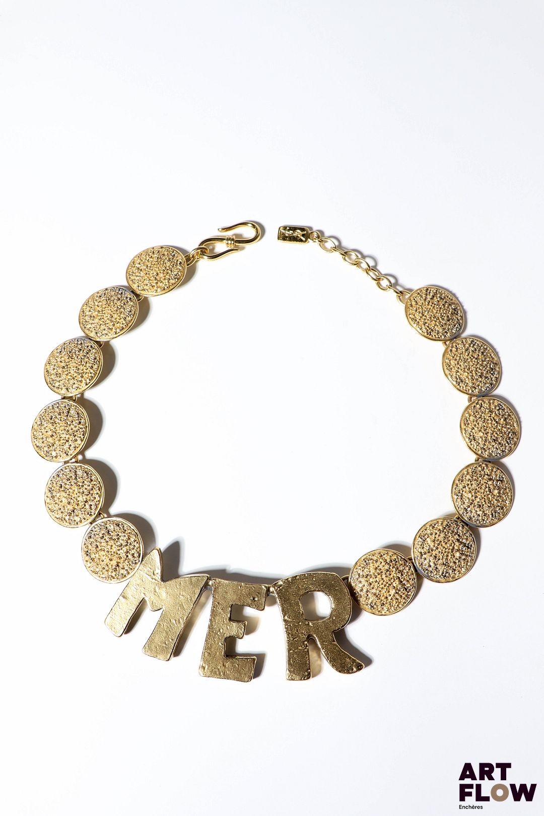 YVES SAINT LAURENT x Goossens Collier MER en métal doré, orné de pastilles texturées et d'un lettrage imposant. Probablement début années 1990. L. 50 cm env. Quelques usures conformes à l'âge de la pièce et dédorures. Provenance : collection de la famille d'un ami et collaborateur de Robert Goossens.
