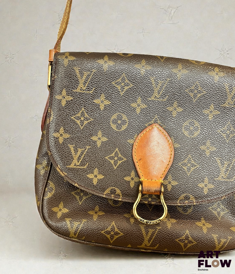 LOUIS VUITTON Modèle Saint cloud Sac besace en toile enduite monogrammée et cuir naturel, fermoir pression sur rabat, poche intérieure zippée et poche plaquée au dose, bandoulière réglable. Signé Tampon Louis Vuitton Paris Made in France Dim. H. : 20 cm x L. : 25 cm. Usures, craquelures, tâches.