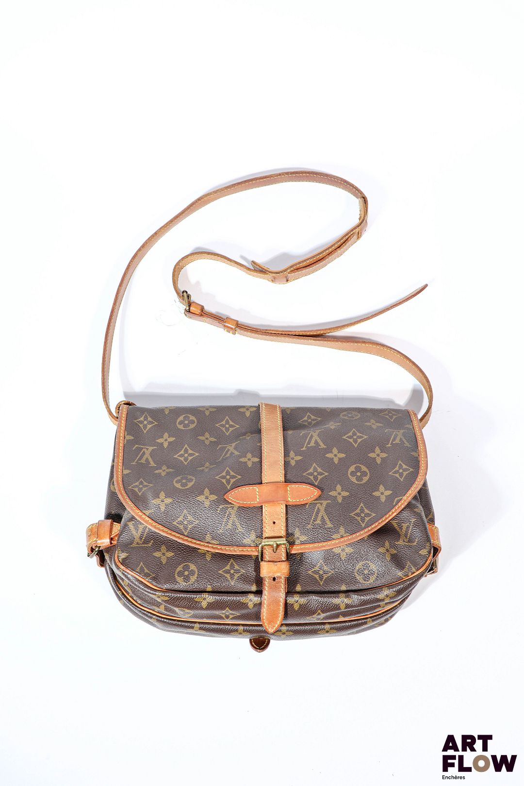 LOUIS VUITTON Sac besace modèle Saumur en toile Monogramm à double sacoches, fermeture sangles, pattes de serrage, anse bandoulière réglable. Deux compartiments de part et d'autre. Dim : 30 x 20 cm Bon état général malgré quelques défauts (usures d'usage, petites taches)