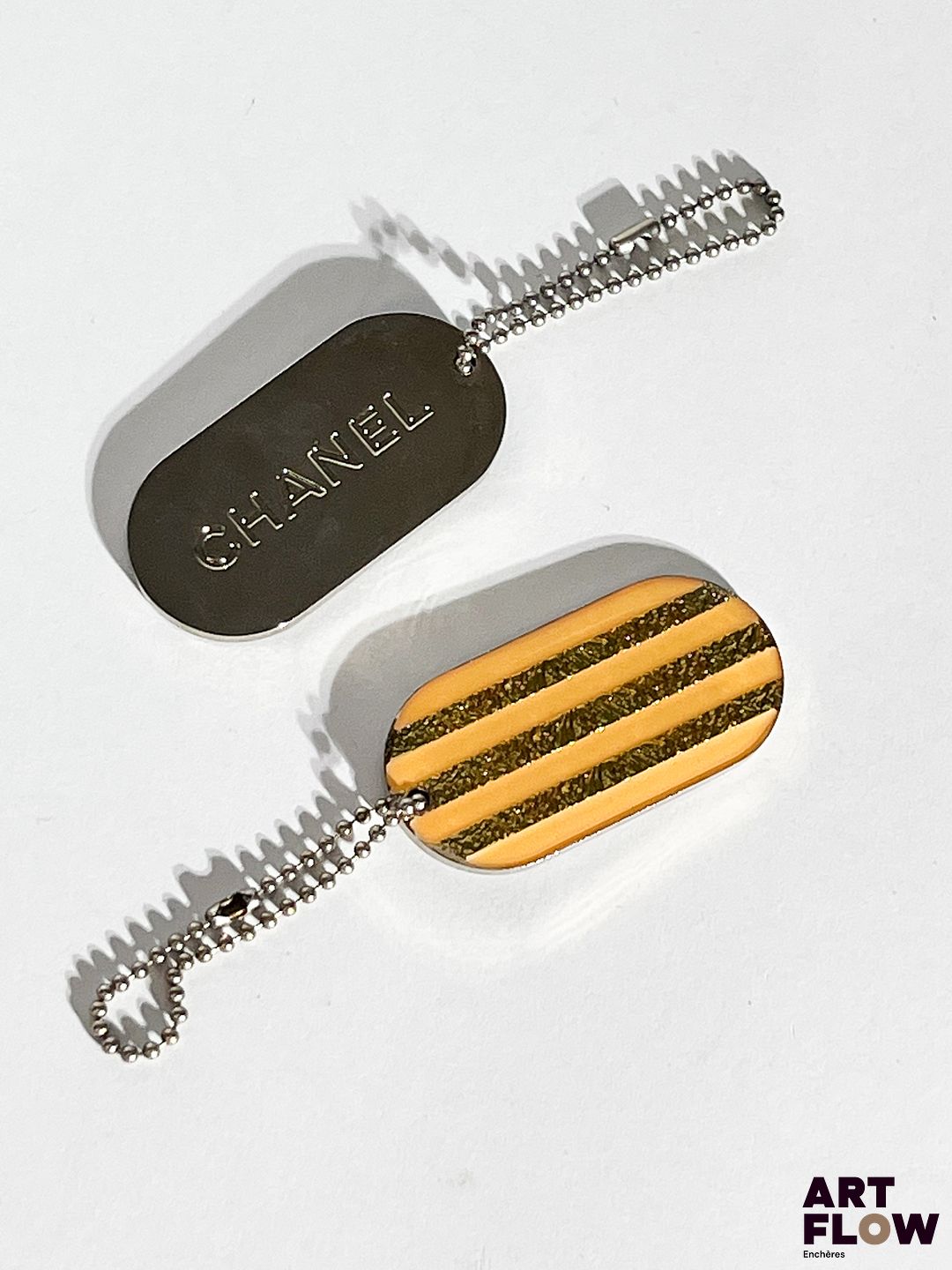 CHANEL Ensemble de deux porte-clés en métal argenté. Dimensions : H. 2,5 x L. 5 cm