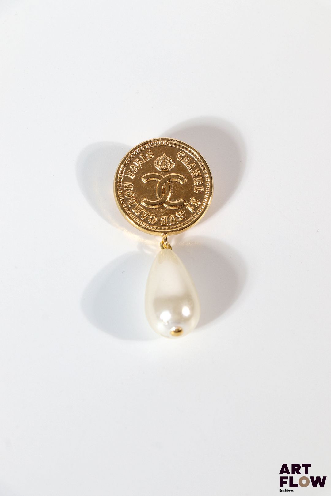 CHANEL Collection Automne/Hiver 1986-1987 Broches imitant une pièce ornée d'une pampille en perle d'imitation Très bon état général Accident (perle à recoller)