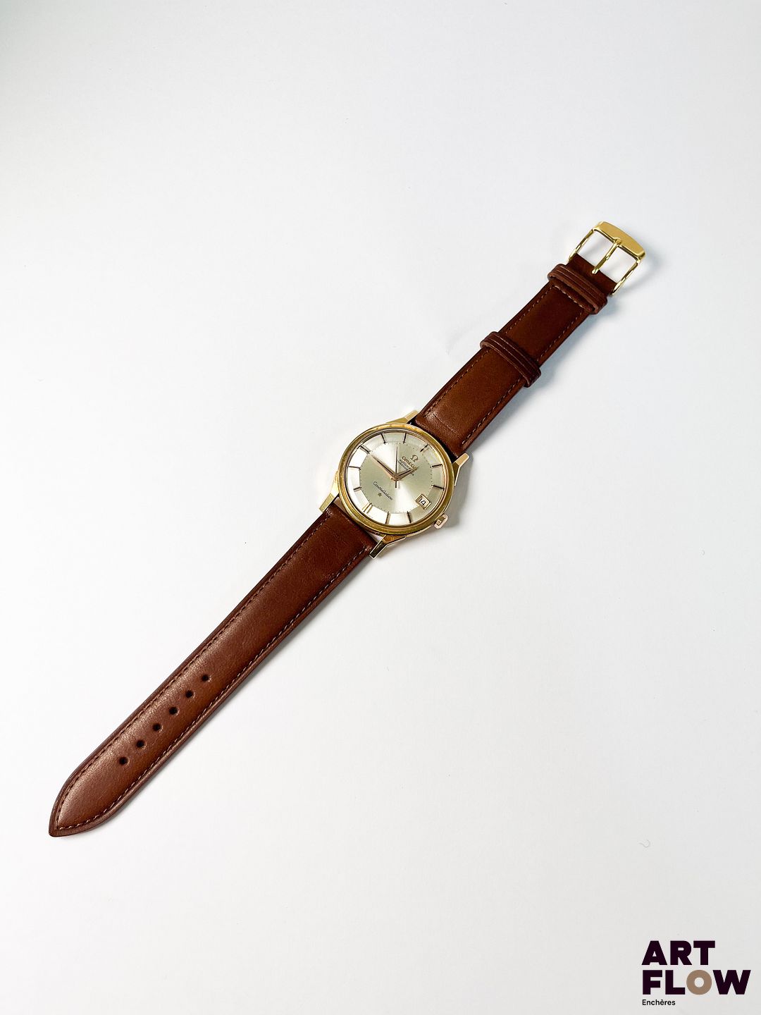 OMEGA Modèle Constellation Montre bracelet homme en or rose 750/°°, à mouvement mécanique à remontage automatique, le boîtier rond à cadran à fond argenté soleillé "pie-pan", index bâtons, guichet date à 3h Poinçon Paul Franck et fils Années cira 1960 Diamètre 34 mm Longueur du bracelet : 19 cm env. Poids brut : 45,73 gr Bon état général Fonctionnelle au moment de la rédaction du catalogue, mécanisme non garanti. L'Omega Constellation Pie Pan apparaît dans les années 1950 au sein de la collection Omega Constellation de Omega, reconnue pour sa précision certifiée chronomètre. Elle se distingue par son cadran facetté en forme de « pie-pan » et ses cornes “dog-leg”, devenant l’un des designs les plus emblématiques de la marque. Le poinçon de maître permet également d’en apprendre davantage sur cette pièce. En effet, la manufacture Paul Franck était spécialisée dans la fabrication de boîtiers en métaux précieux à Taverny. Dans les années 1960, les villes de Taverny et de Saint-Leu-la-Forêt constituaient le principal centre de fabrication de boîtiers de montres de la région parisienne. Expert : Monsieur Alexis Francis-Boeuf