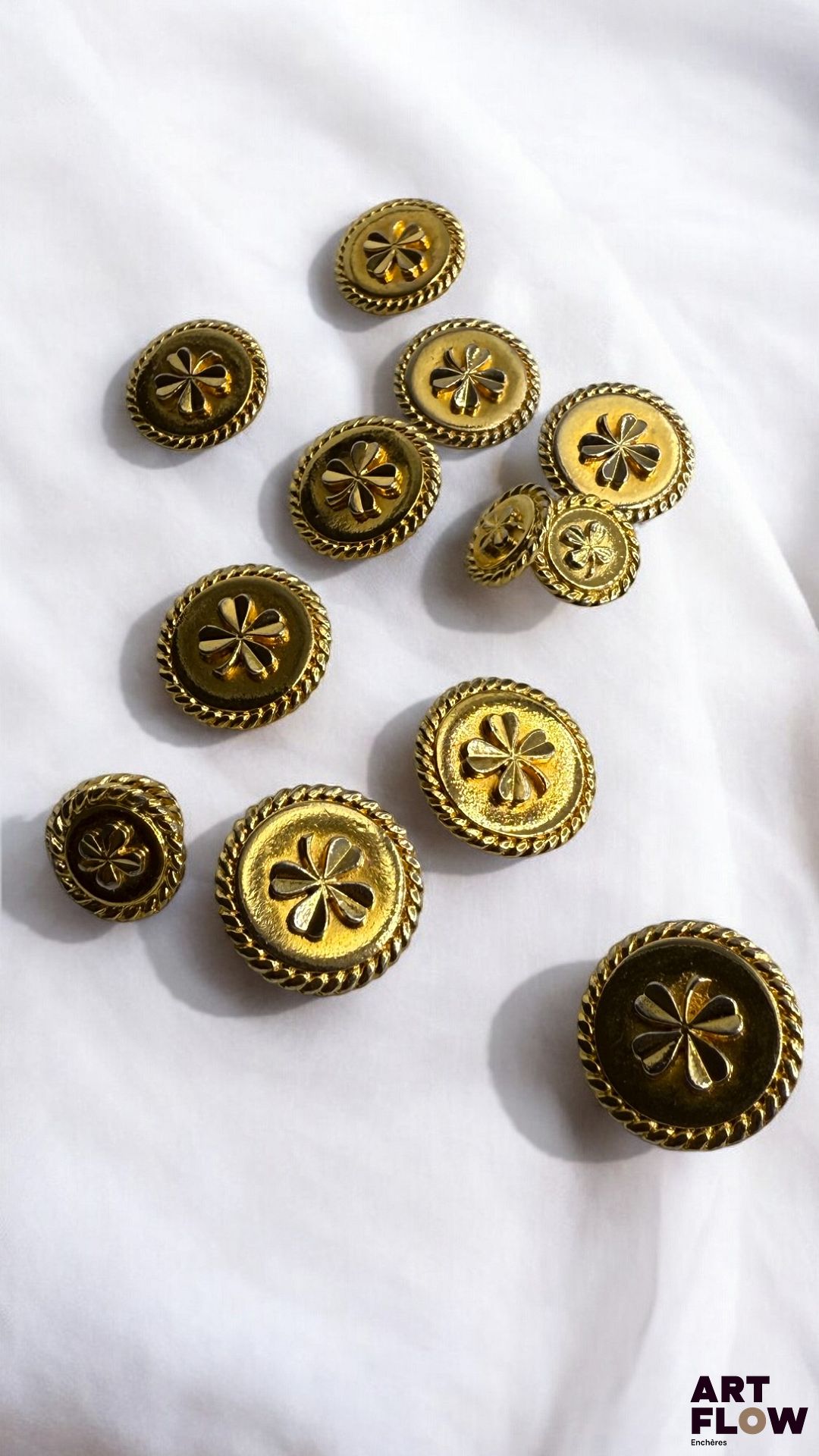 CHANEL Lot de 13 boutons dorés à décor de trèfles, dont 4 plus petits. Quelques petites usures, boutons dédorés par endroits