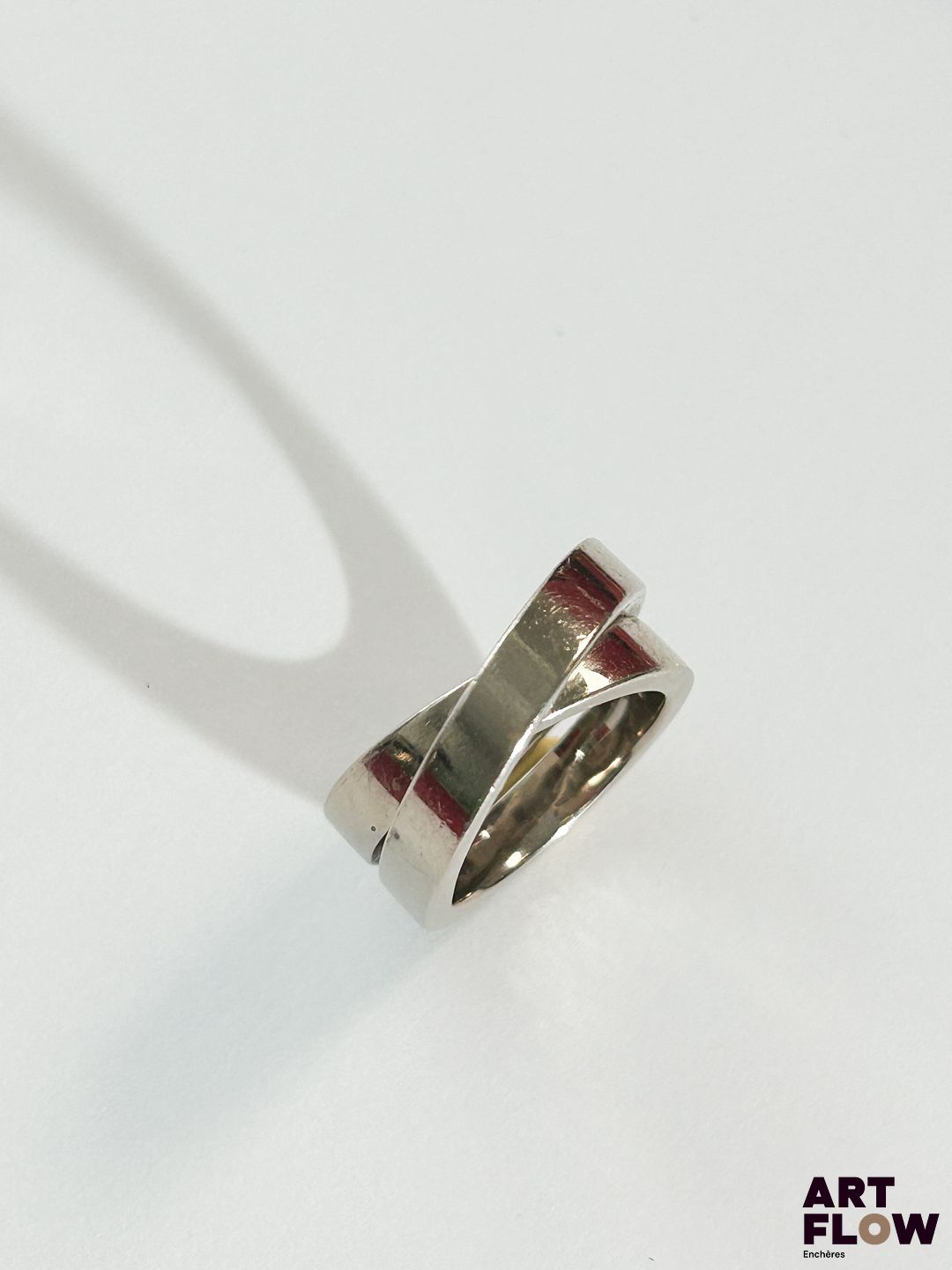 CARTIER Modèle "Nouvelle vague" Bague en or gris 18k (750/1000) figurant deux anneaux entrelacés Signée et numérotée Poids : 15,08 g TDD : 48 Avec facture Dans son écrin, sa boite et avec son sac d'origine Usures