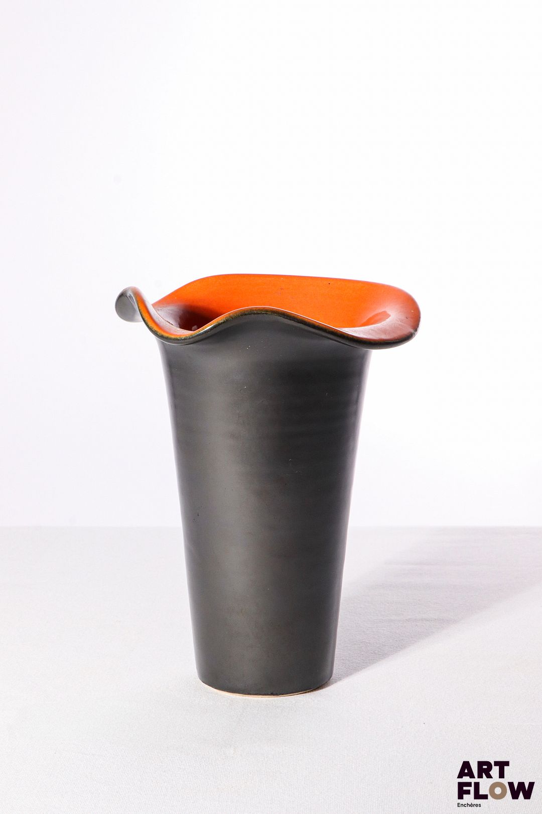 POL CHAMBOST (1906-1983) Vase 860 "Corolle" en faience émaillée à couverte noire à l'extérieur et terracotta à l'intérieur. Incisé du monogramme "PC" au revers et tampon "860" 20 x 15 cm Bibliographie : Philippe Chambost, "Pol Chambost, Sculpteur-Céramiste 1906-1983", Somogy Editions d'Art, Paris, 2006, modèle similaire p. 68