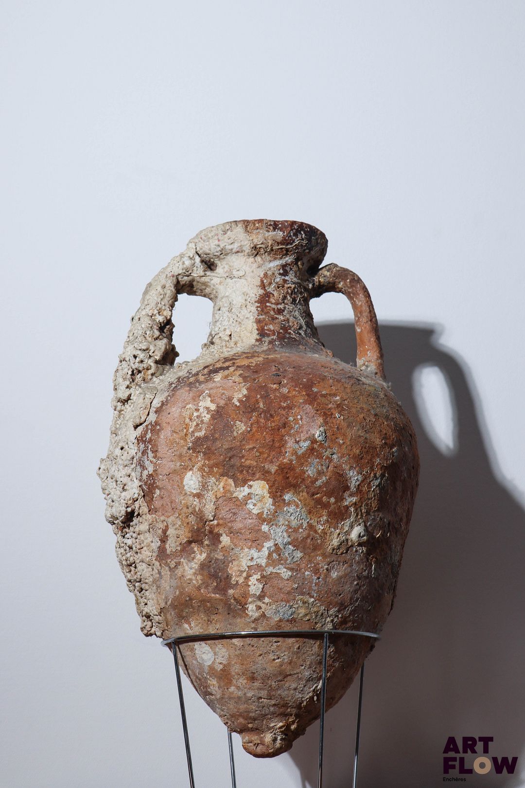 Amphore à deux anses en terre cuite. Epoque Antique. Concrétions et usures. Petits fissure visible dans la partie basse. H. 65 cm env. *Expédition déconseillée.