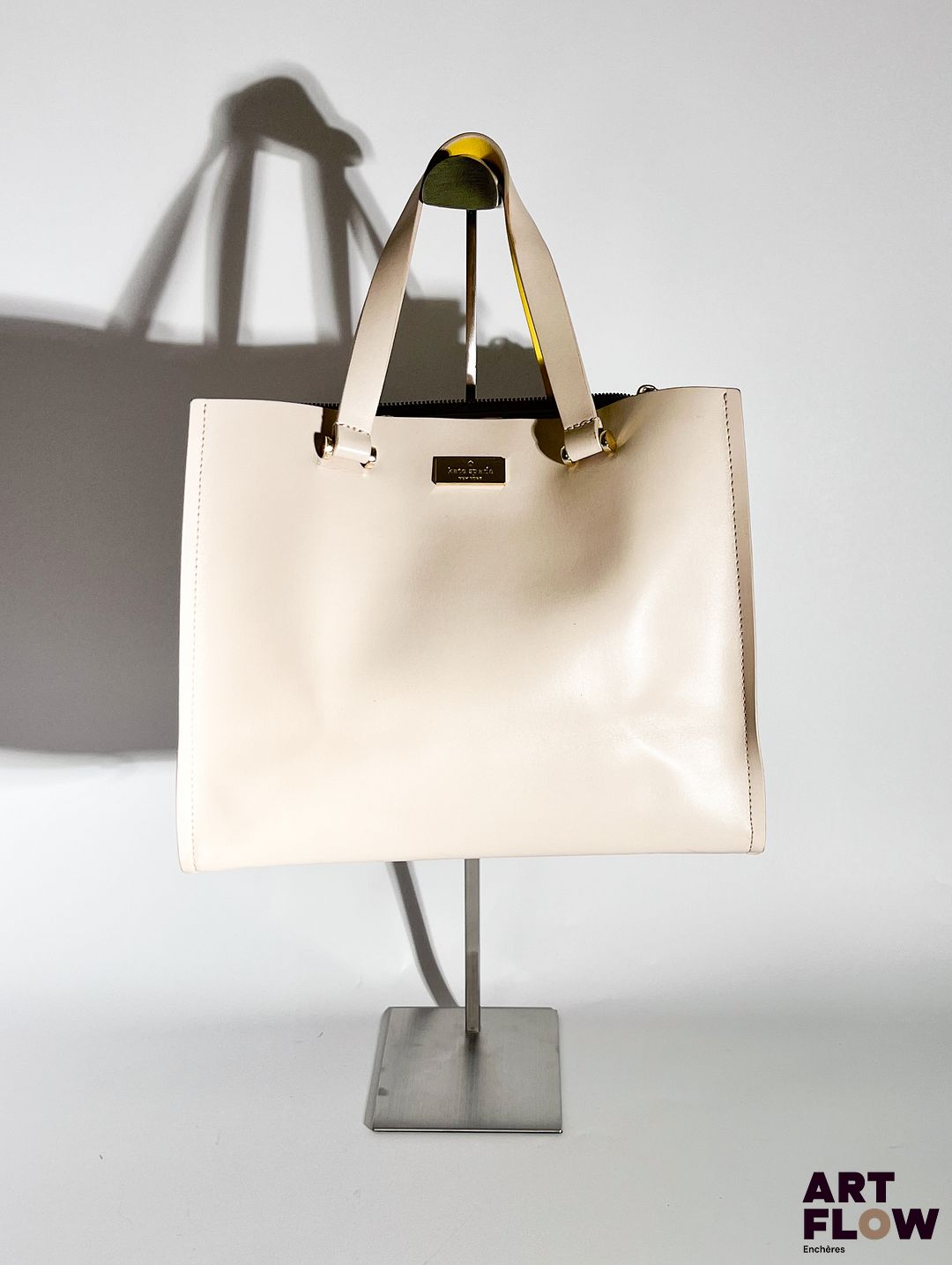 KATE SPADE Sac à main en cuir rose poudré, bijouterie en métal doré, fermeture éclair, garniture intérieure en cuir jaune. Dimensions : H. 26 x L. 31 cm Dégâts aux anses. En l'état