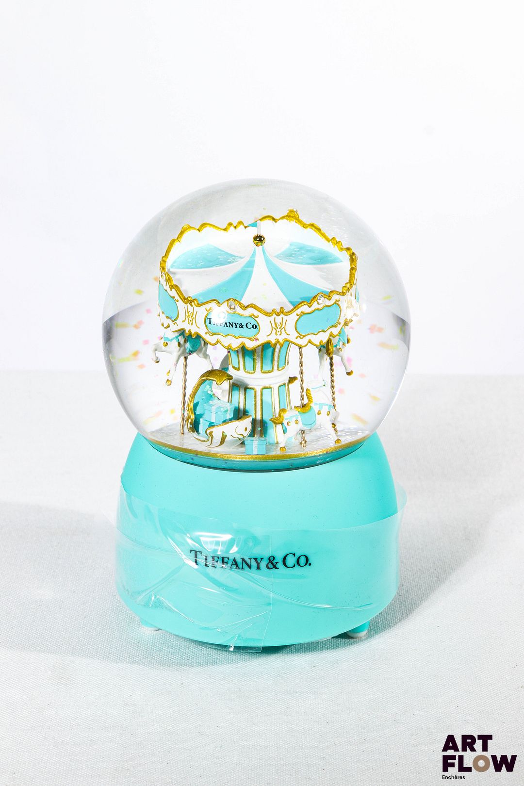 TIFFANY & CO Boule à neige faisant office de boîte à musique. L'intérieur figurant un carrousel. Édition limitée. Fonctionnelle. H. 15 cm Dans son coffret d'origine État neuf
