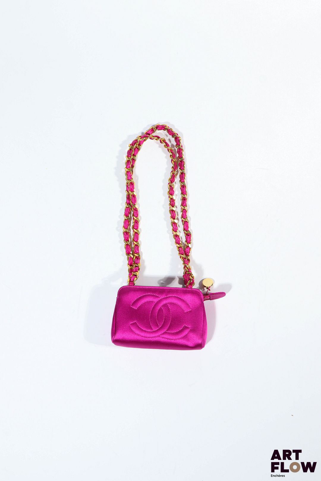 CHANEL Micro-sac en satin fuschia, bandoulière en chaine dorée et satin, fermeture zippée. Années 1990 Dim. : H. 8 x L.13 cm x P. 4,5 cm