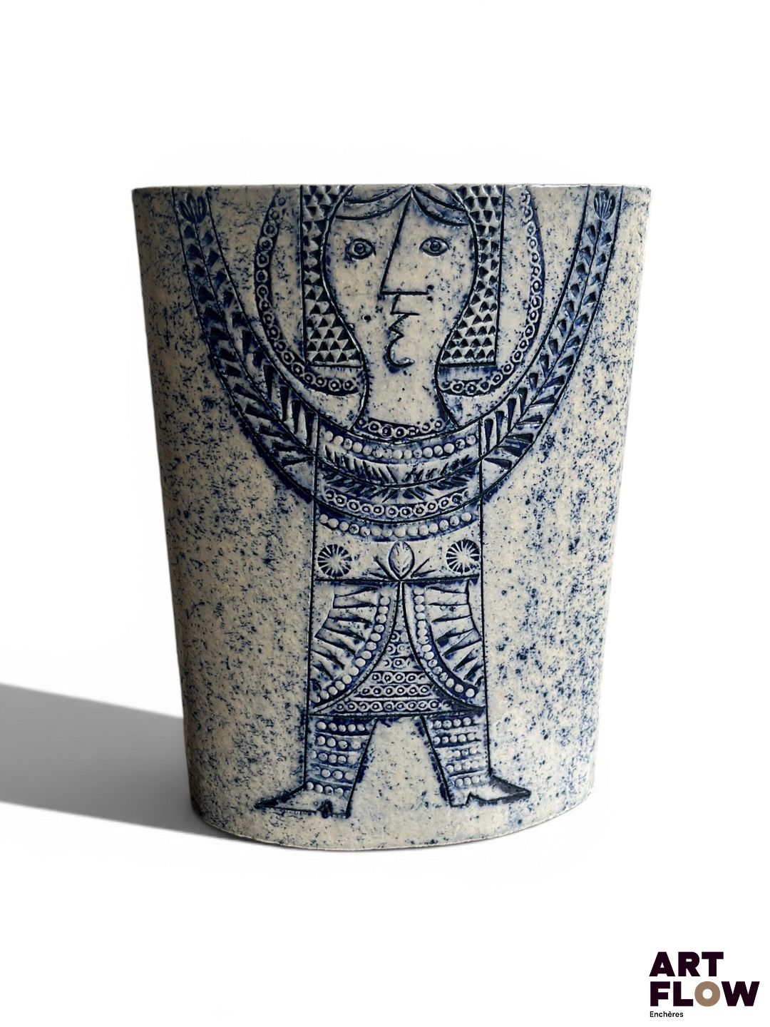Roger CAPRON (1922-2006) Modèle "Ellipse" Vase de forme elliptique à trois compartiments en grès grand feu émaillé gris bleu à décor incisé figurant un personnage féminin levant les bras. Signé du cachet Capron Vallauris France Dimensions : H. 31,5 x L.23 x P. 10,5 cm Egrenures à la base du vase (voir photos) Nous exprimons notre gratitude à la famille Capron pour son éclairage.