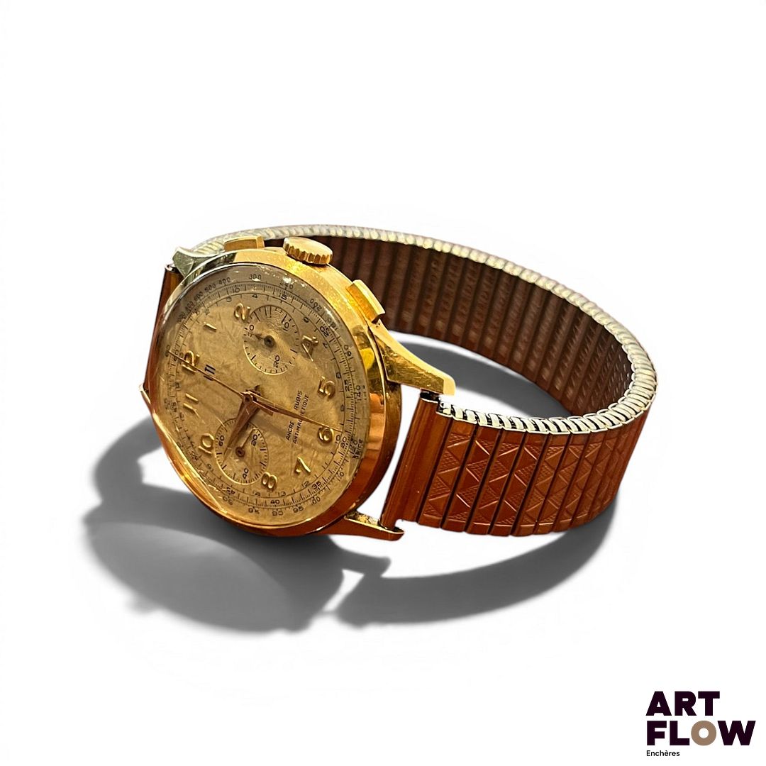 UTI Montre bracelet chronographe, boîtier en or 750/°°, cadran doré, chiffres arabes appliqués, chemin de fer. Bracelet en métal "fixoflex". Mécanisme non garanti. Fonctionnelle lors de la rédaction du catalogue. Verre accidenté. Poids brut : 64,59 gr