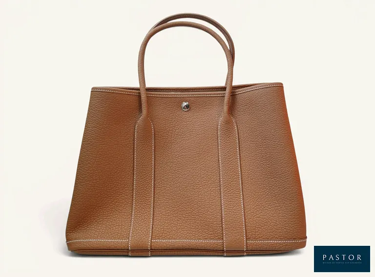 HERMÈS. Sac à main "Garden Party" en veau négonda gold, doublure en toile chevron beige, bijouterie en métal palladié, fermeture par pression clou de selle, H.26 x L.36 x P.17 cm. Année de fabrication : 2024. Etat proche du neuf, avec dust-bag et boîte. Expertise Jérôme Lalande  - TVA Récupérable