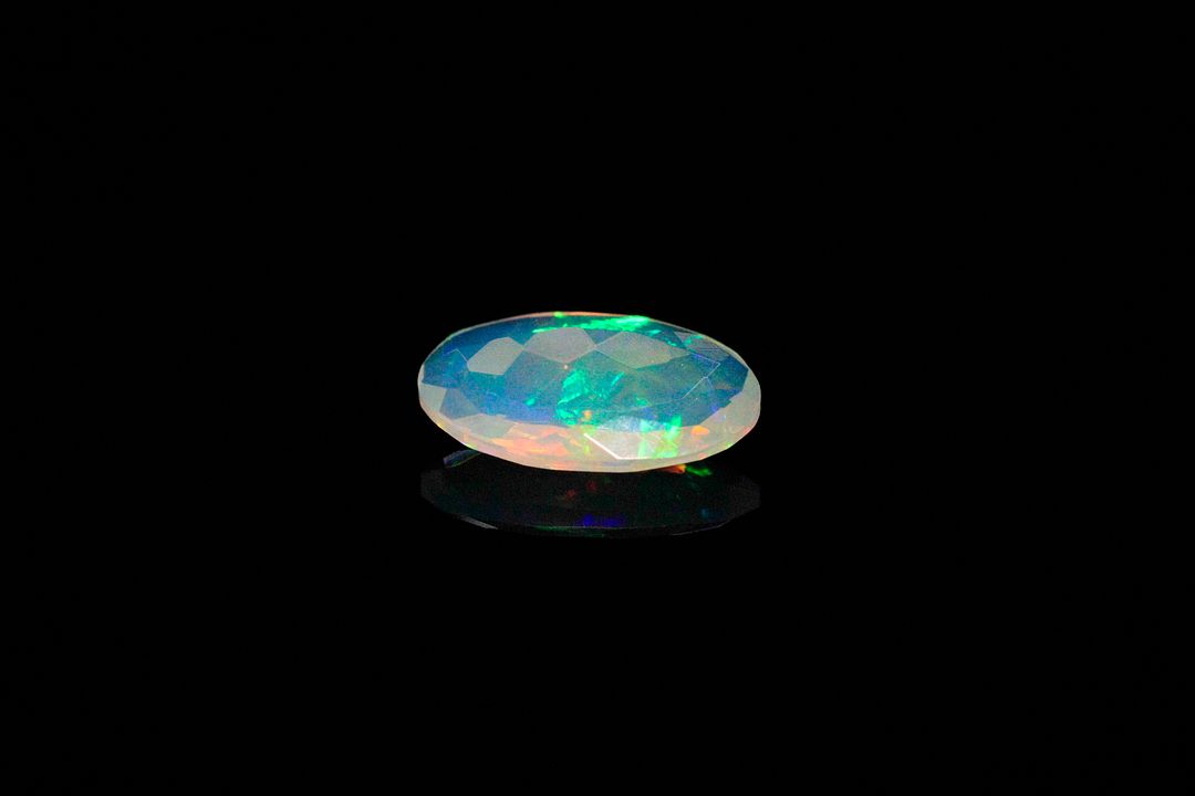Opale facettée blanche ovale. Beaux éclats de couleur. 1.28 ct. 12.1mm x 7.0mm