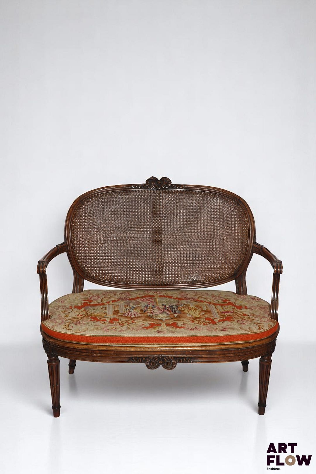 Canapé en bois mouluré et sculpté posant sur pieds cannelés à asperges, assise et dossier à fond de canne ; le dossier orné d'un noeud. Style Louis XVI. H 96 cm Accidents et restaurations.