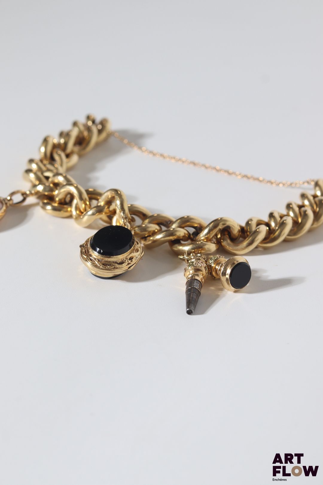 Bracelet gourmette en or jaune 18k (750/°°) à larges mailles et charm’s. Poids brut : 40,71 gr