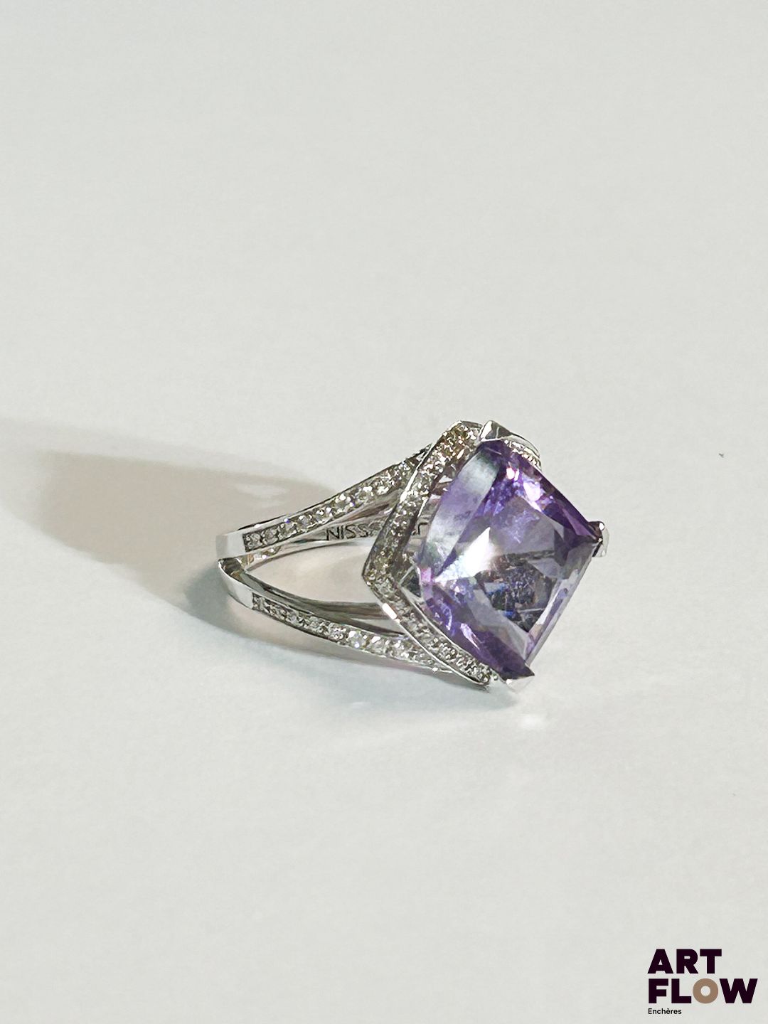 MAUBOUSSIN Modèle "Fou de toi" Bague en or blanc 18k (750/1000) et platine 950, centrée d'une améthyste de taille losangique et ornée de petits diamants Signée et numérotée TDD : 48 Poids brut : 5,75 g Avec certificat et facture Dans sa boite, et surboite d'origine