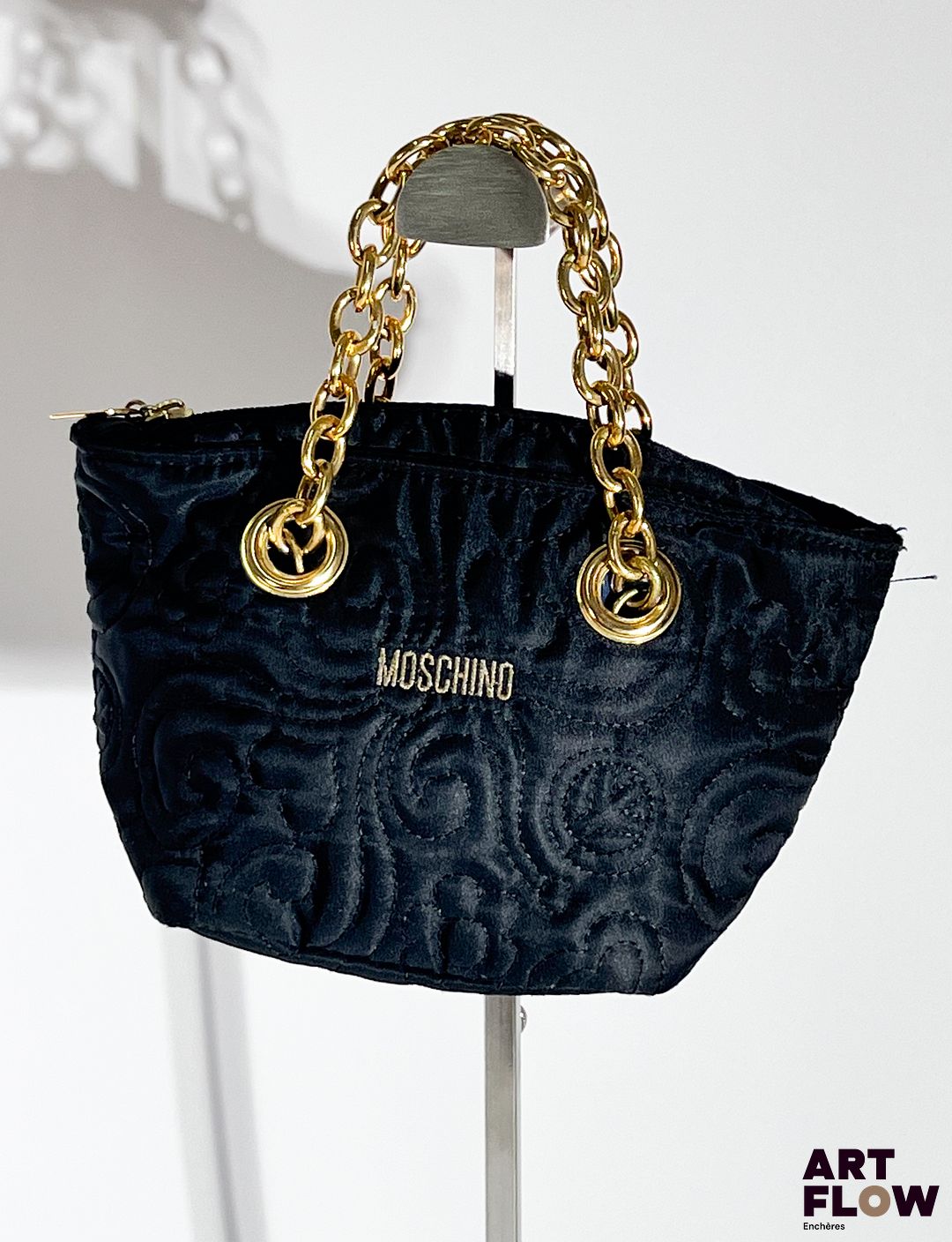 MOSCHINO Petit sac en tissu matelassé à décor de fleurs, bijouterie et chaine en métal doré, fermeture éclair. Dimensions : H. 13 x L. 22 cm