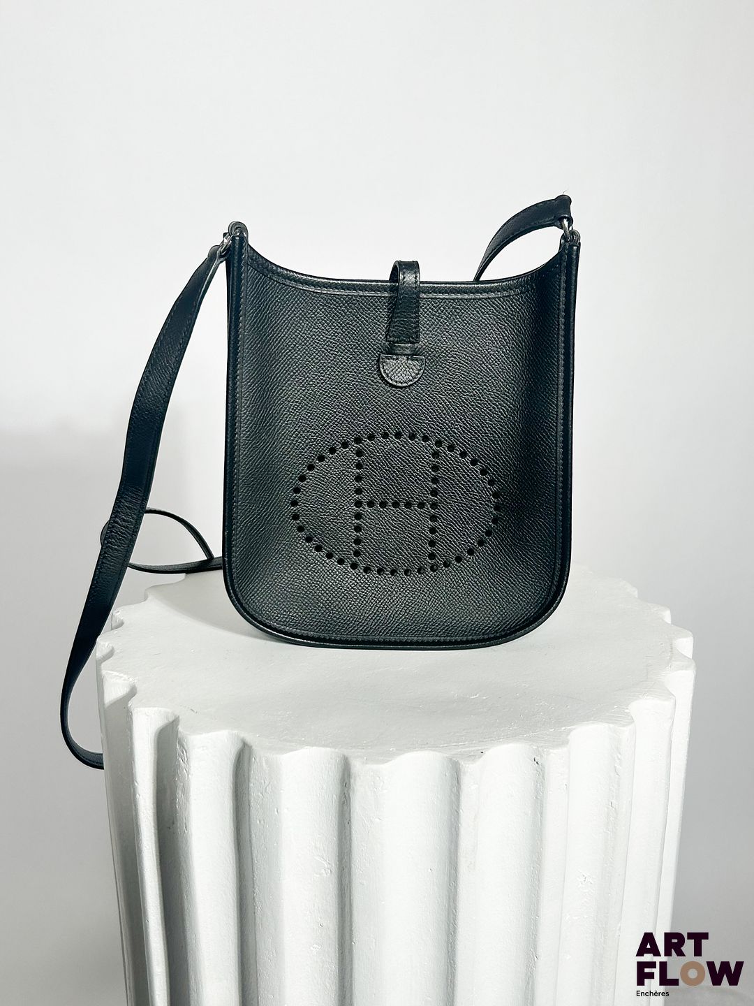 HERMÈS Paris Modèle Mini Evelyne Sac en cuir noir avec bandoulière, fermoir pression sous patte Dimensions : H.18 x L.18 cm Dans son dustbag et sa boîte d'origine