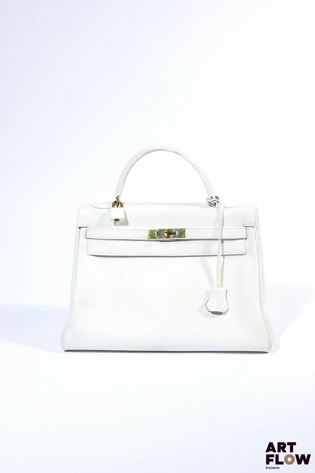 HERMÈS Paris Modèle Kelly 32 cm Sac à main en veau evergrain blanc, bijouterie en métal doré. Avec clochette, cadenas gainé et clef Cuir sain, malgré quelques traces d'usage.