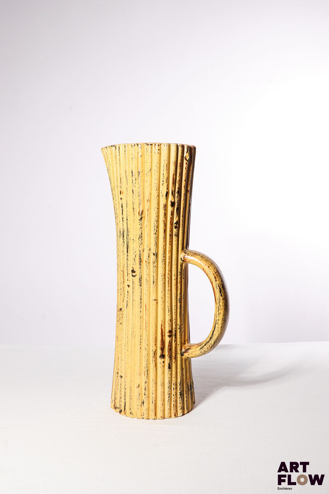 POL CHAMBOST (1906-1983) Pichet en faience émaillée à couverte polychrome, de nforme oblongue striée. Incisé sous la base "Made in France, Poterie Pol Chambost, déposé" H. 32 cm Bibliographie : Philippe Chambost, "Pol Chambost, Sculpteur-Céramiste 1906-1983", Somogy Editions d'Art, Paris, 2006, modèle similaire p. 96