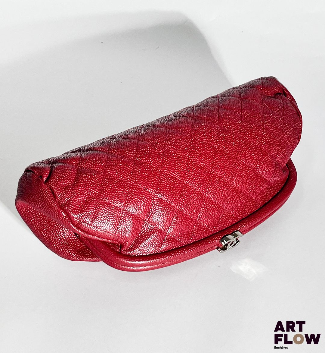 CHANEL Circa 2008 Pochette Timeless matelassée en cuir rouge, bijouterie en métal argenté, fermeture clipsée orné du monogramme Chanel. Modèle de Soldes Dimensions : H. 16 x L. 28 cm