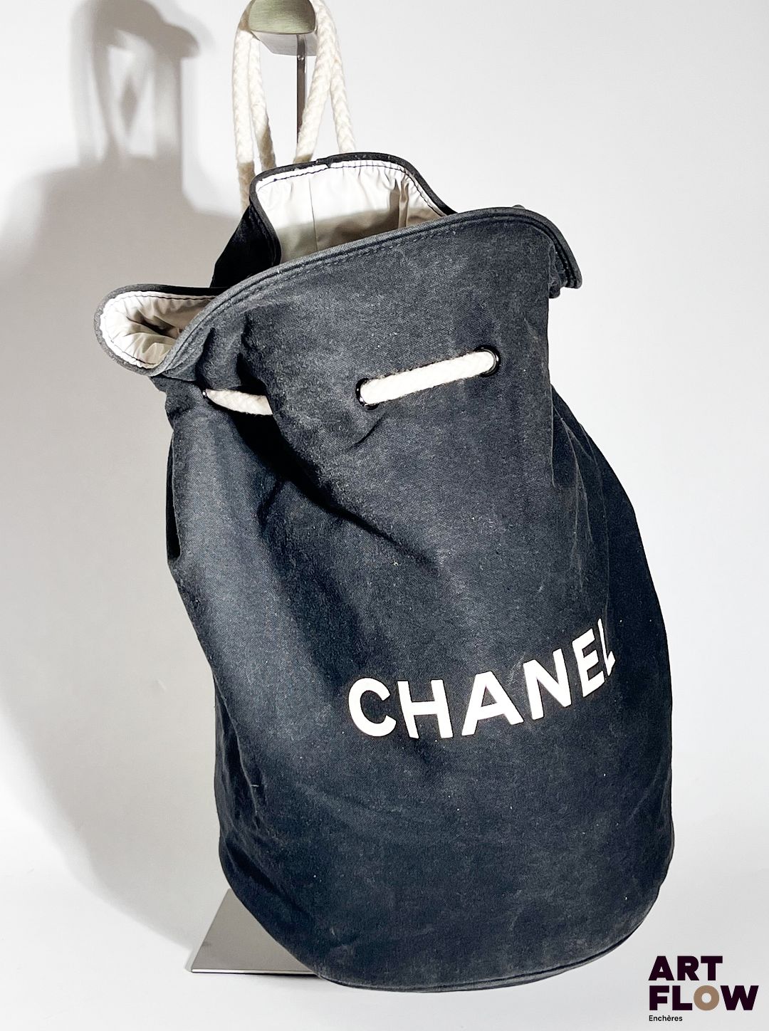 CHANEL Sac sceau en tissu noir, fermeture par cordon en tissu blanc, garniture intérieure en toile enduite blanche. Dimensions : H. 35 Tissu légèrement décoloré