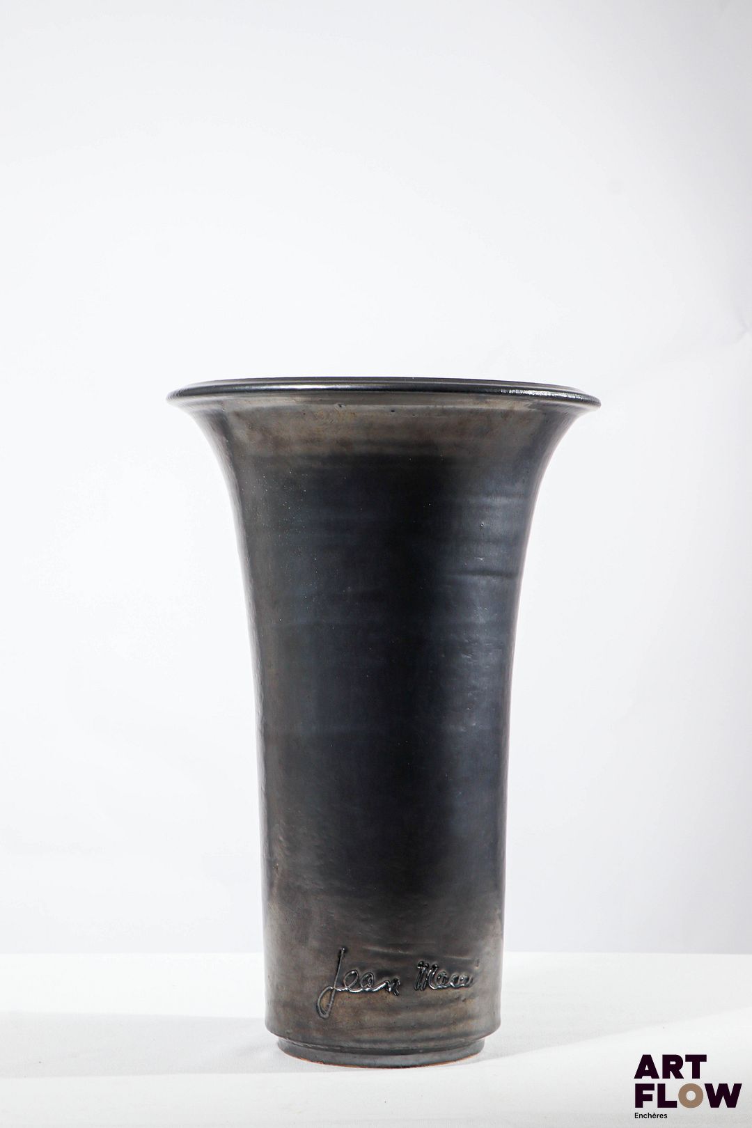 JEAN MARAIS Vase rouleau à col évasé en terre cuite à glaçure noire. Signé. H. 32 cm Très bon état général.
