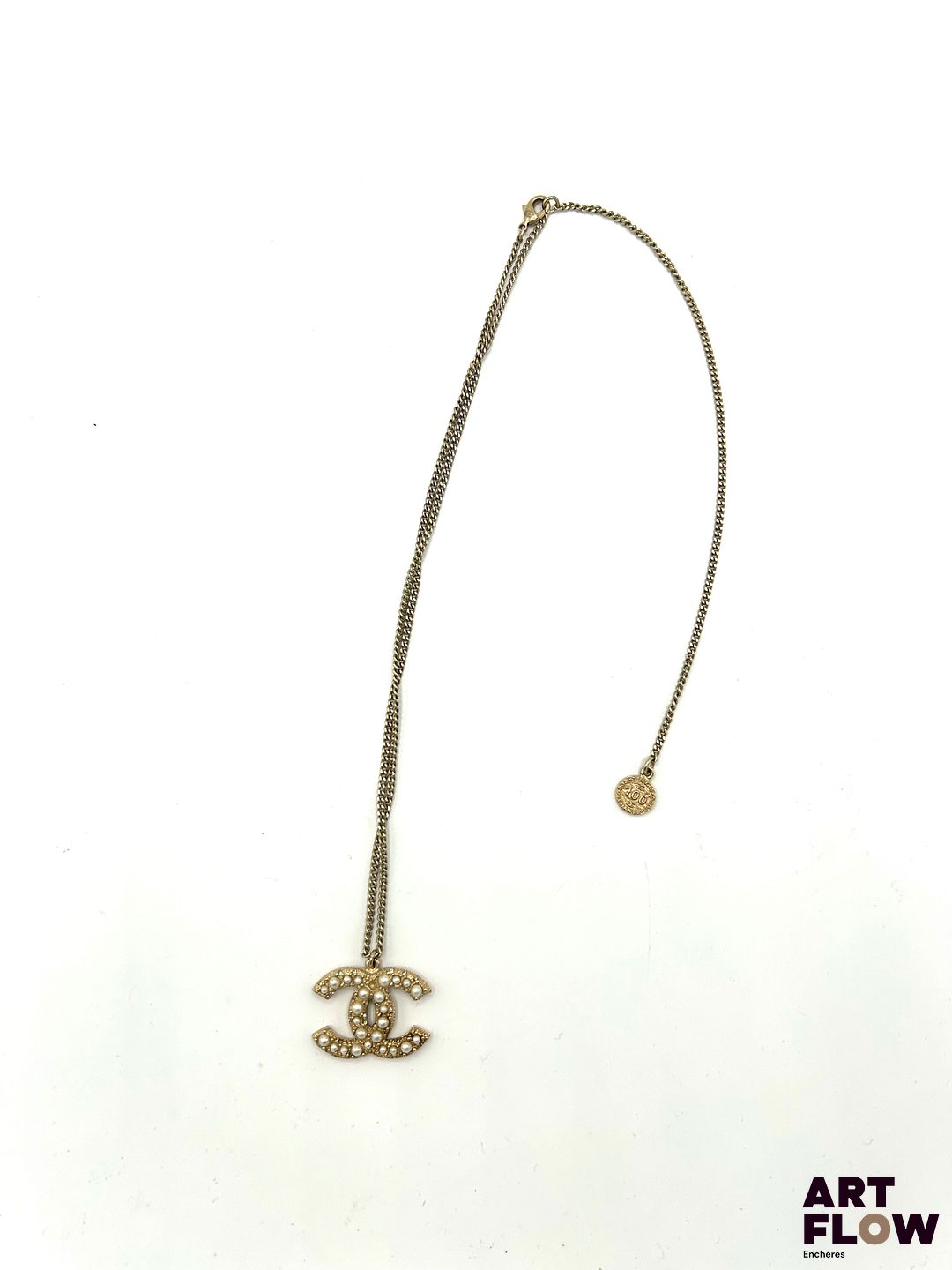 CHANEL Collier en métal doré retenant un pendentif orné de perles. Signé