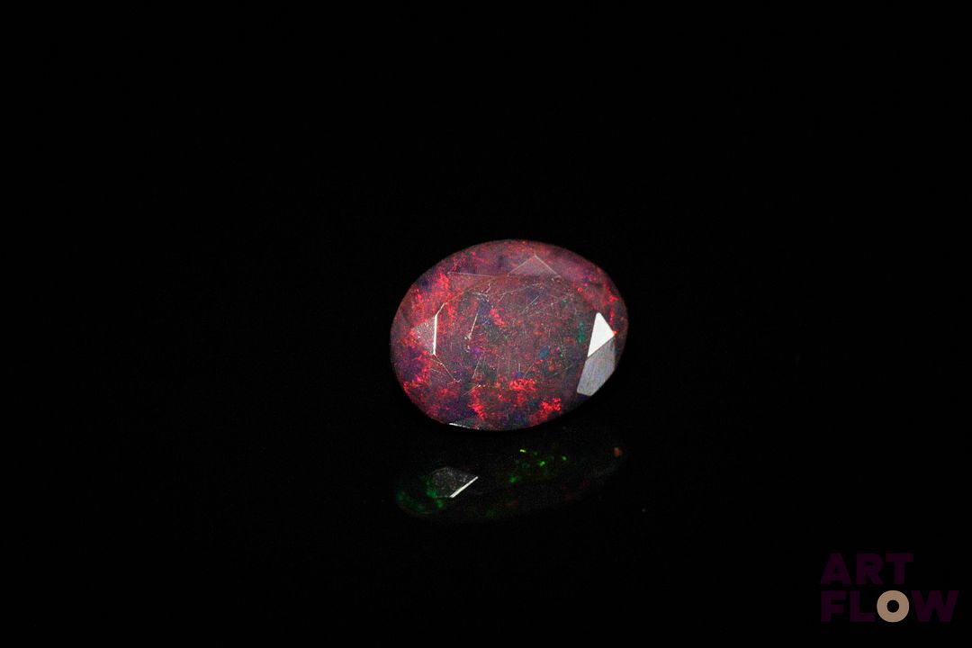 Opale noire facettée ovale. Jolie couleur, dominante rouge. 1.79 ct. 10.2mm x 7.9mm