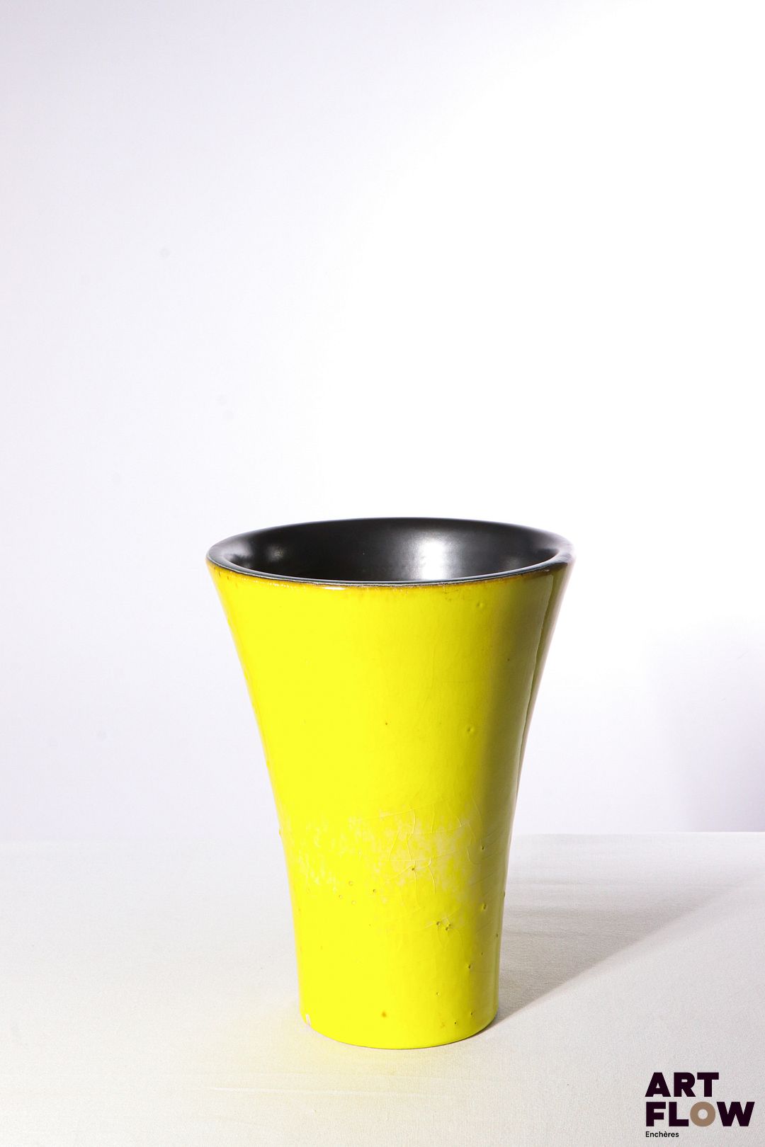POL CHAMBOST (1906-1983) Vase rouleau à col évasé en faience émaillée, l'extérieur à couverte jaune (bullée), l'intérieur à couverte noire. Incisé sur l'envers "Poterie Pol Chambost, numéro illisible, Made in France" 25 x 19 cm Petit saut d'émail sur la base Bibliographie : Philippe Chambost, "Pol Chambost, Sculpteur-Céramiste 1906-1983", Somogy Editions d'Art, Paris, 2006, modèle similaire p. 115