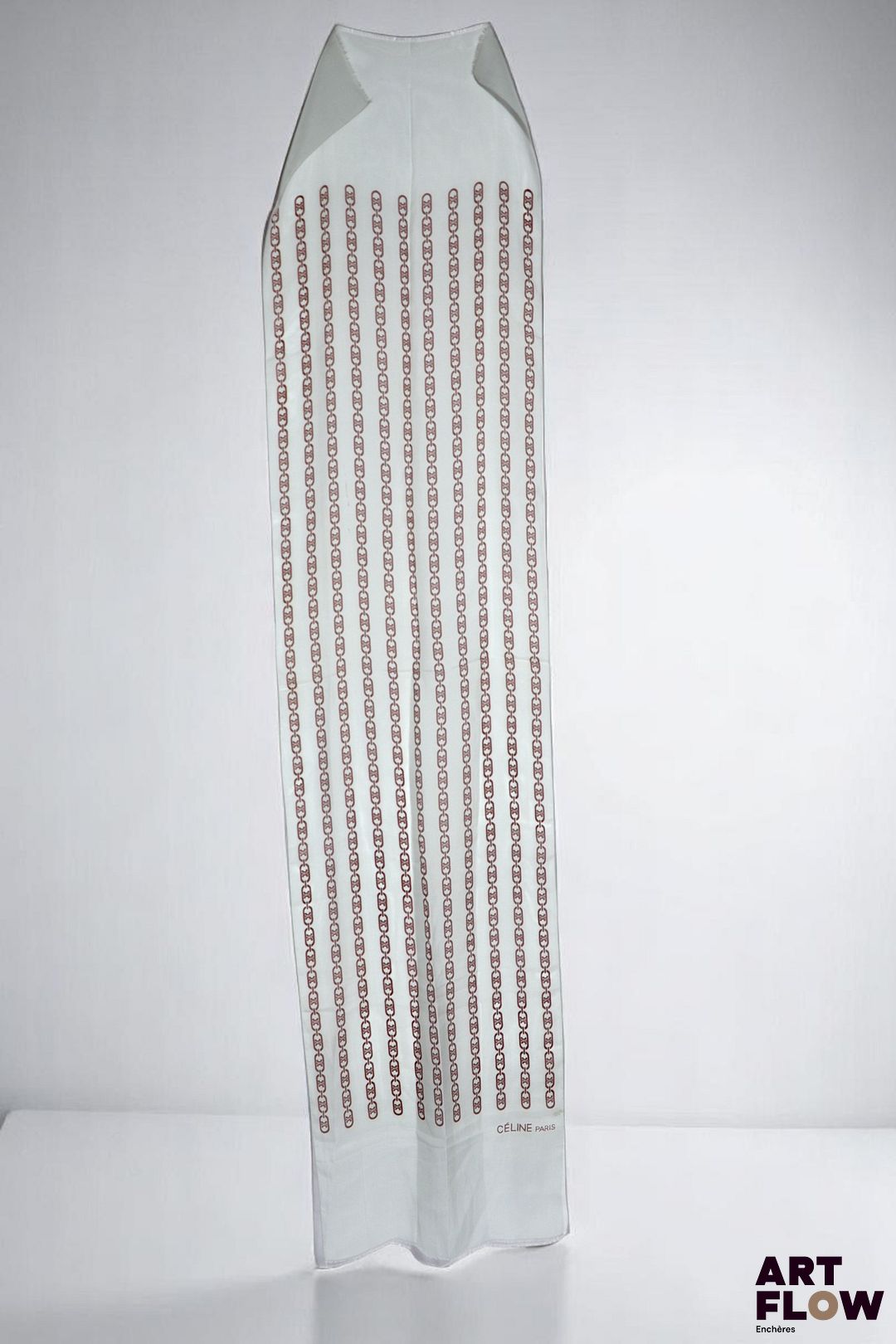 CÉLINE Paris Foulard en soie bleu à décor de chaînes marron chocolat. 160 x 28 cm env.