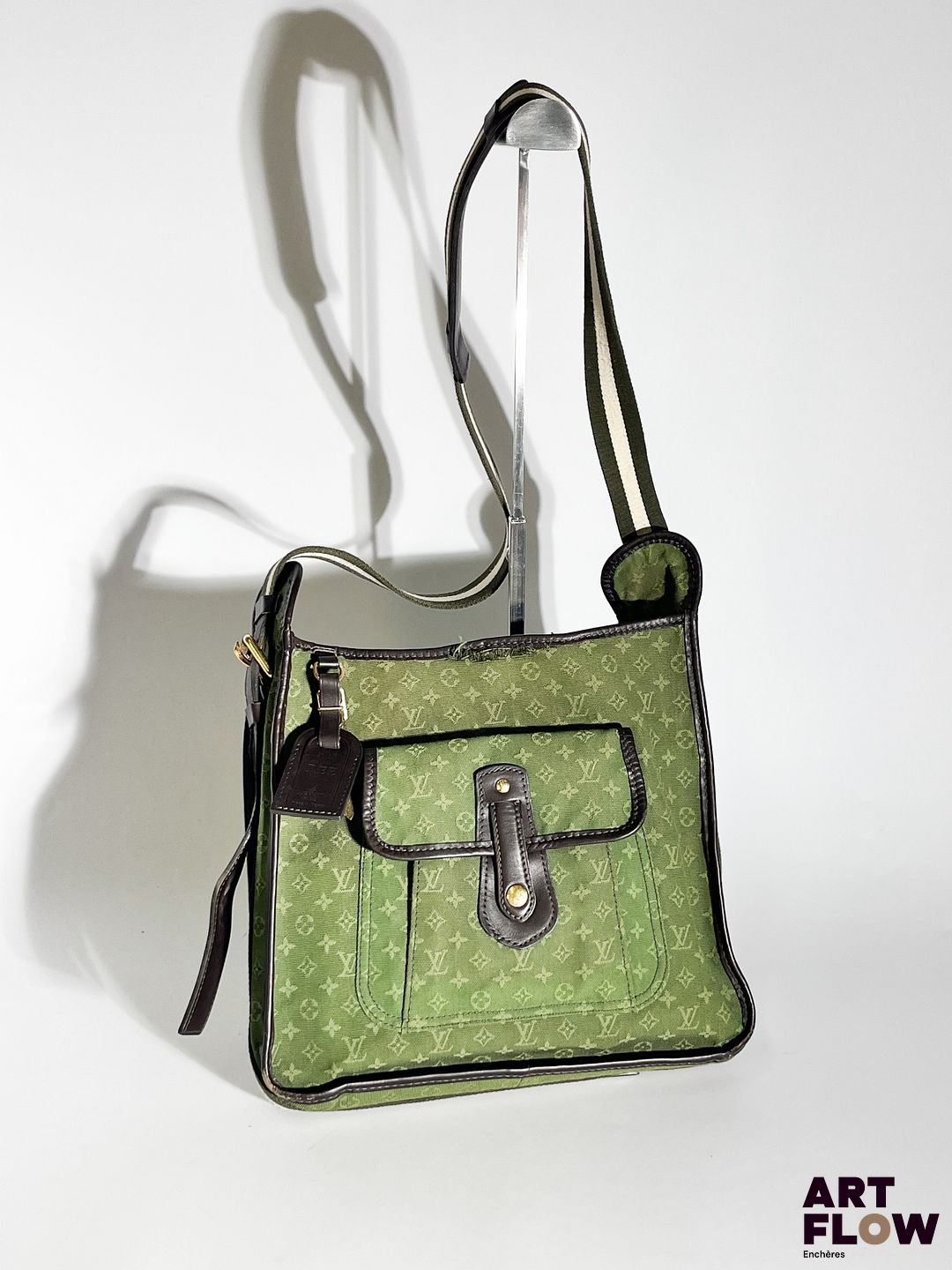LOUIS VUITTON Sacoche en tissu Monogram vert et cuir marron, bijouterie en métal doré, bandoulière en tissu vert et blanc. Dimensions : H. 27 x L. 28 cm Déchirure au niveau de la couture supérieure. En l'état