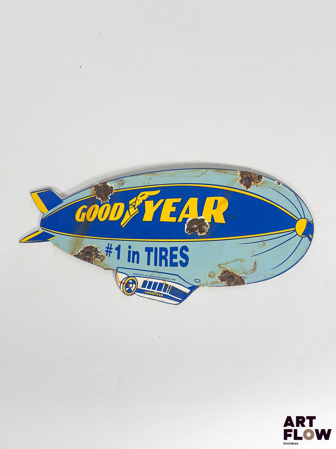 Plaque émaillée Good Year représentant un dirigeable Dimensions : 30 x 14 cm Petits éclats et traces de rouille Reproduction moderne