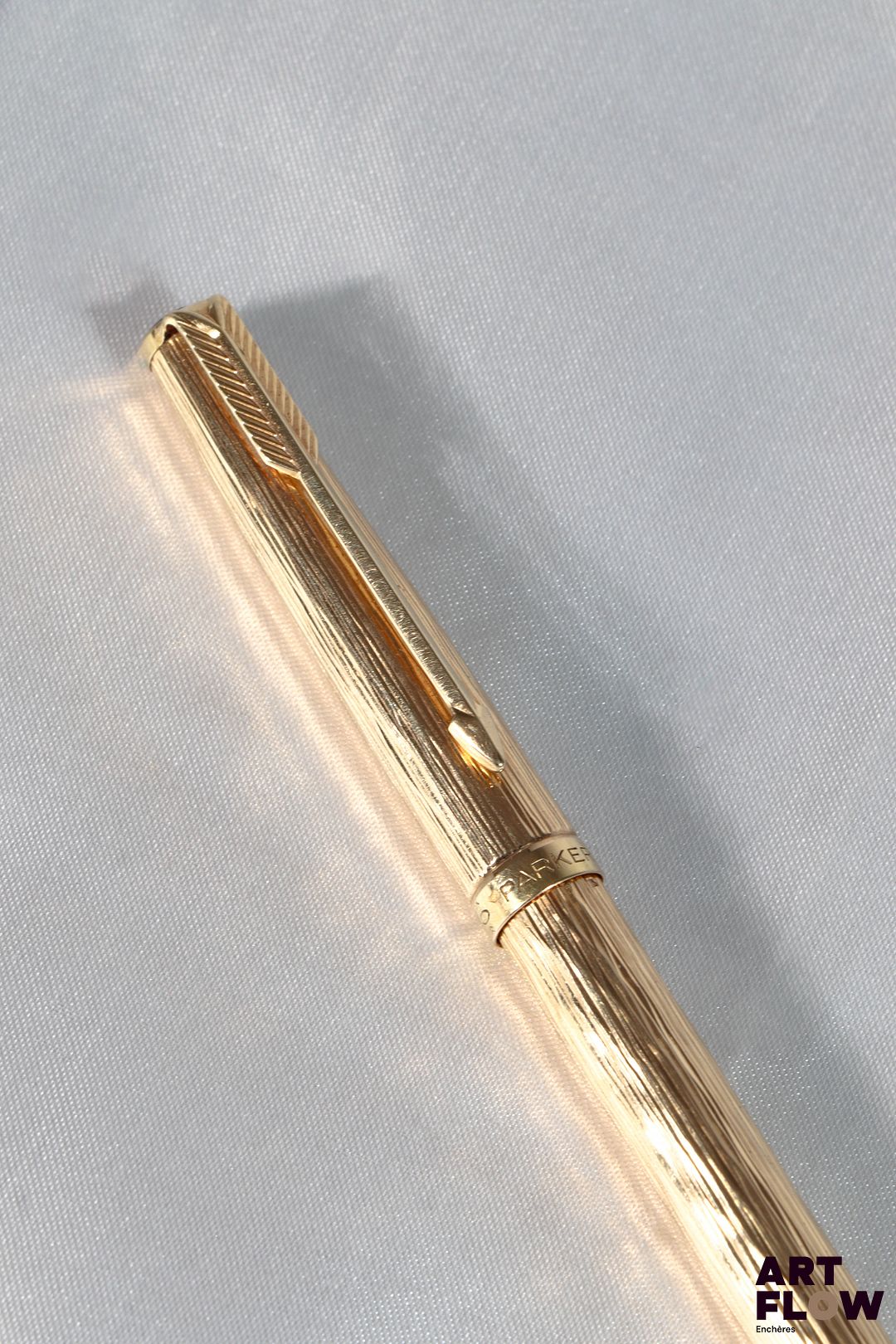 PARKER Stylo bille en or jaune 750/°° à décor d'écorce. Longueur : 13 cm Poids brut : 24,01 g Bon état général malgré quelques légers défauts (usures d'usage)