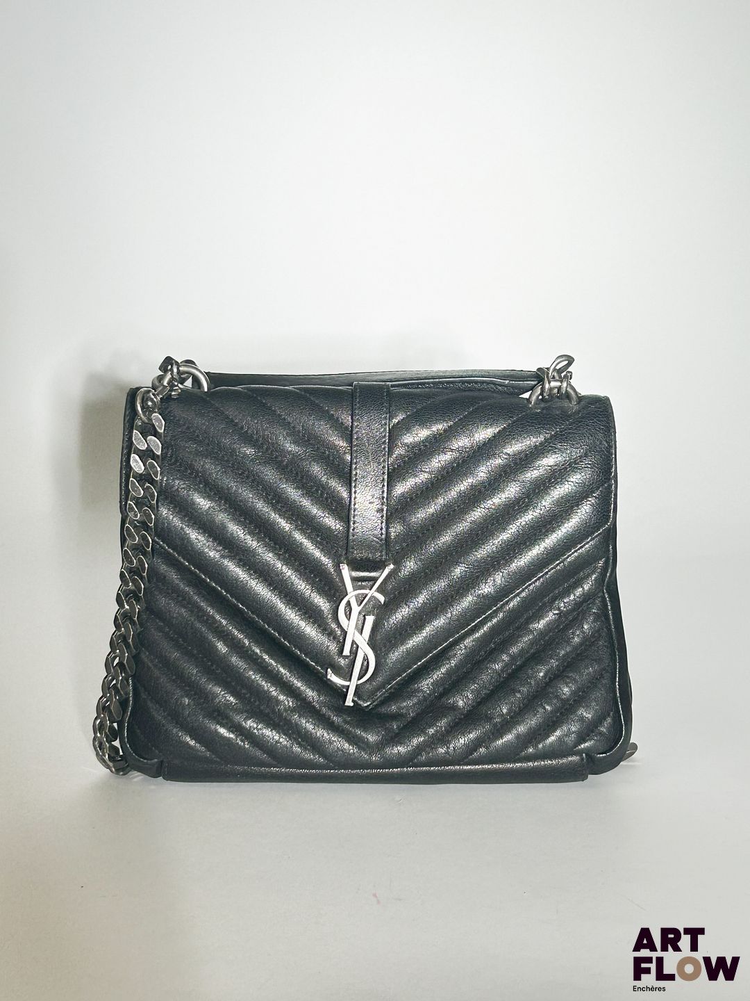 SAINT LAURENT Paris Modèle Loulou Sac bandoulière en cuir noir surpiqué chevrons Fermoir aimanté sous rabat rehaussé du sigle Anse bandoulière chaîne en métal vernissé Intérieur en toile à deux compartiments et poche zippée Dimensions : 19 x 25 x 7,5 cm Petites usures notamment à l'intérieur tâches, traces (voir photos). Manque une partie du logo-fermoir (barre du L)