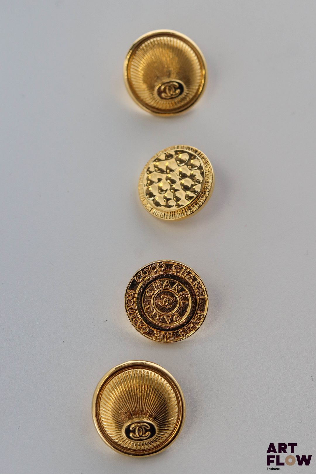 CHANEL Lot de 4 boutons, dont deux assortis à décor guilloché rayonnant.