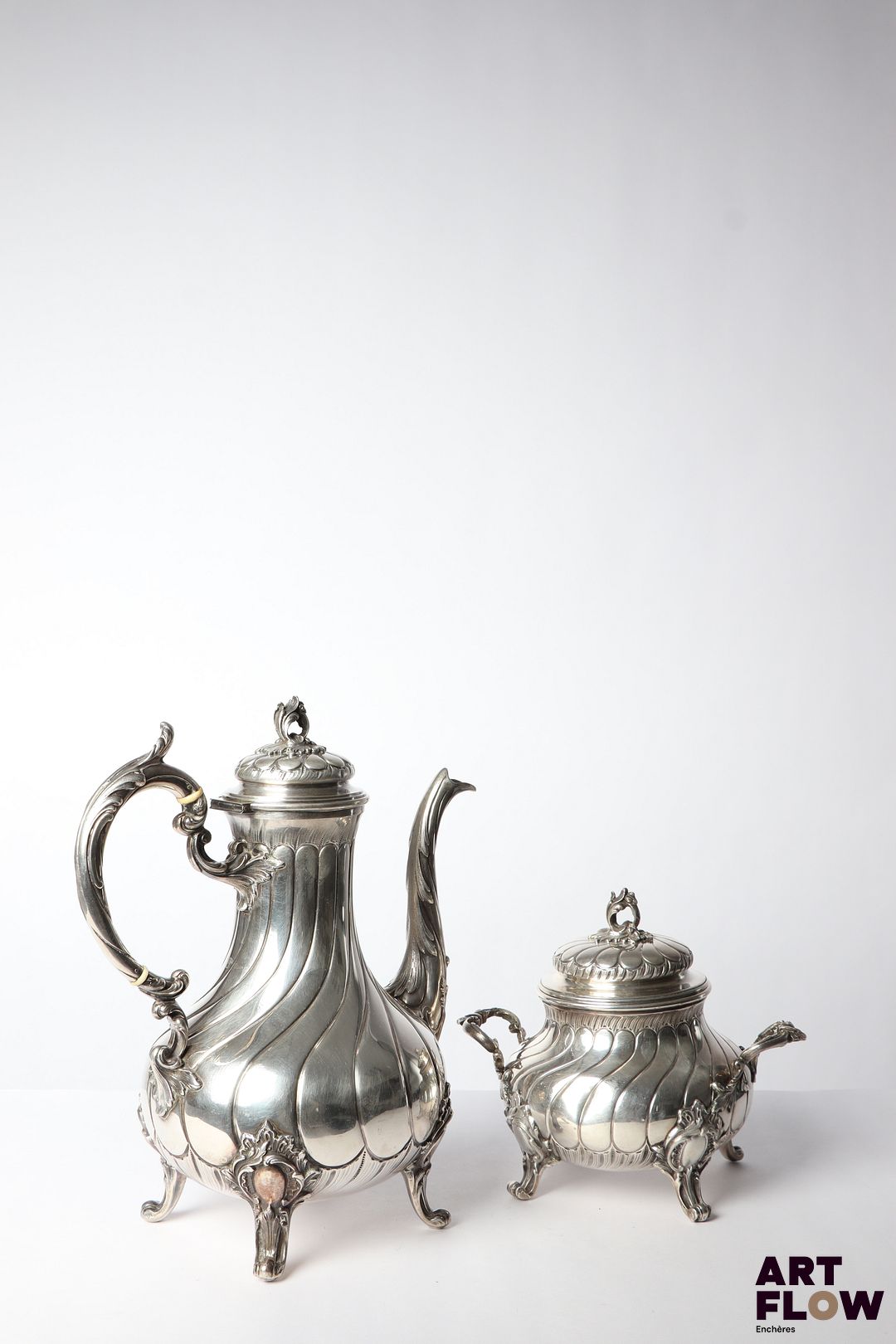 Théière et sucrier en argent (poinçon Minerve) à côtes torses, posant sur pieds légèrement galbés, les anses, frétels et bec verseur ornés de feuilles d'acanthe. Poids brut total : 1077,06