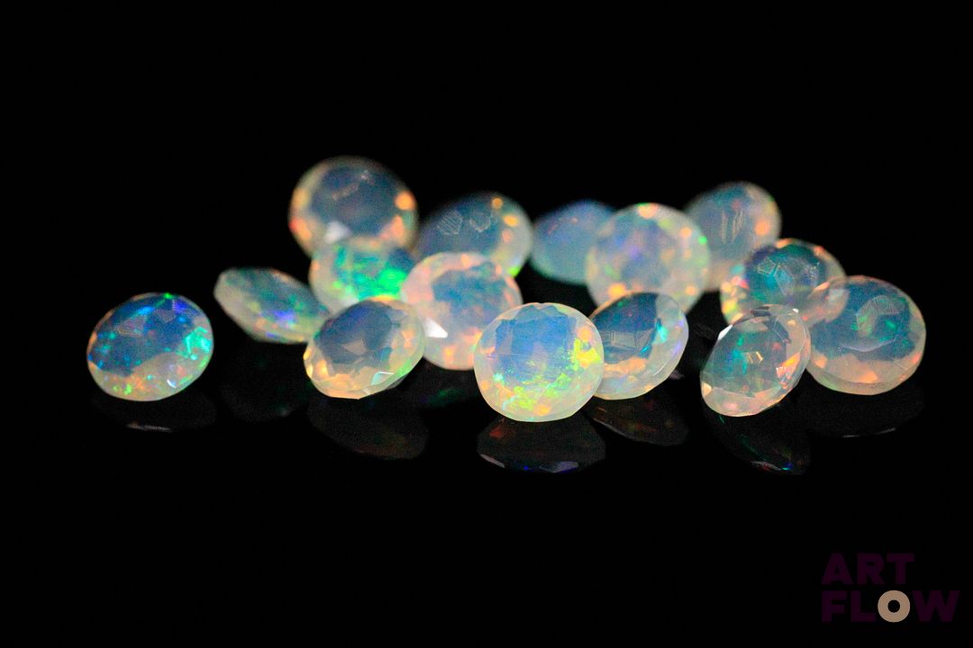 Quinze opales facettées blanches rondes. Beaux éclats de couleur. 4.04 cts. Diam. moy.: 5.0mm