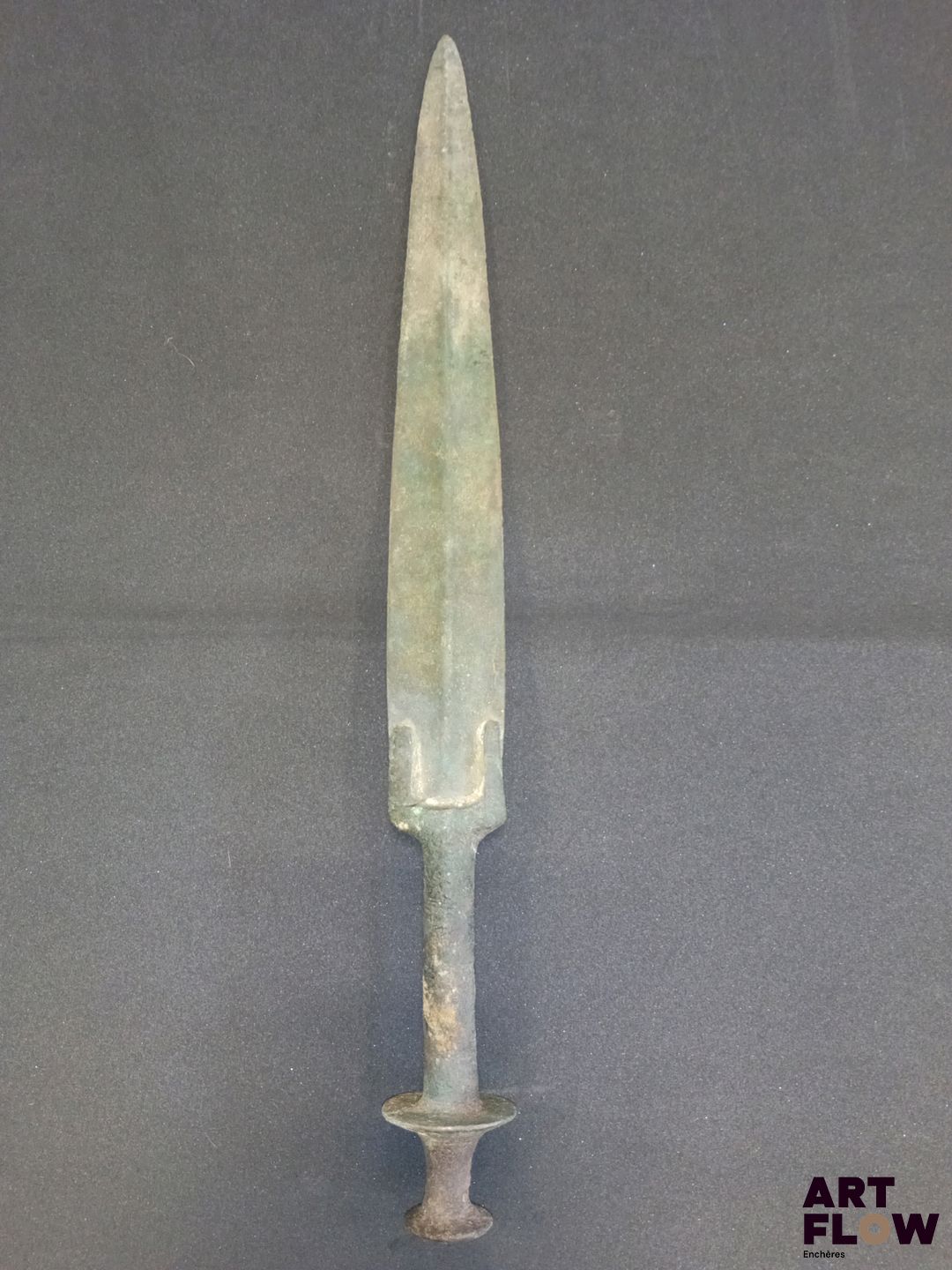 LURISTAN. Dague en bronze à patine verte. Manche se terminant par un pommeau évasé en forme de disque. Premier millénaire avant JC. L. 40,5 cm. En l'état