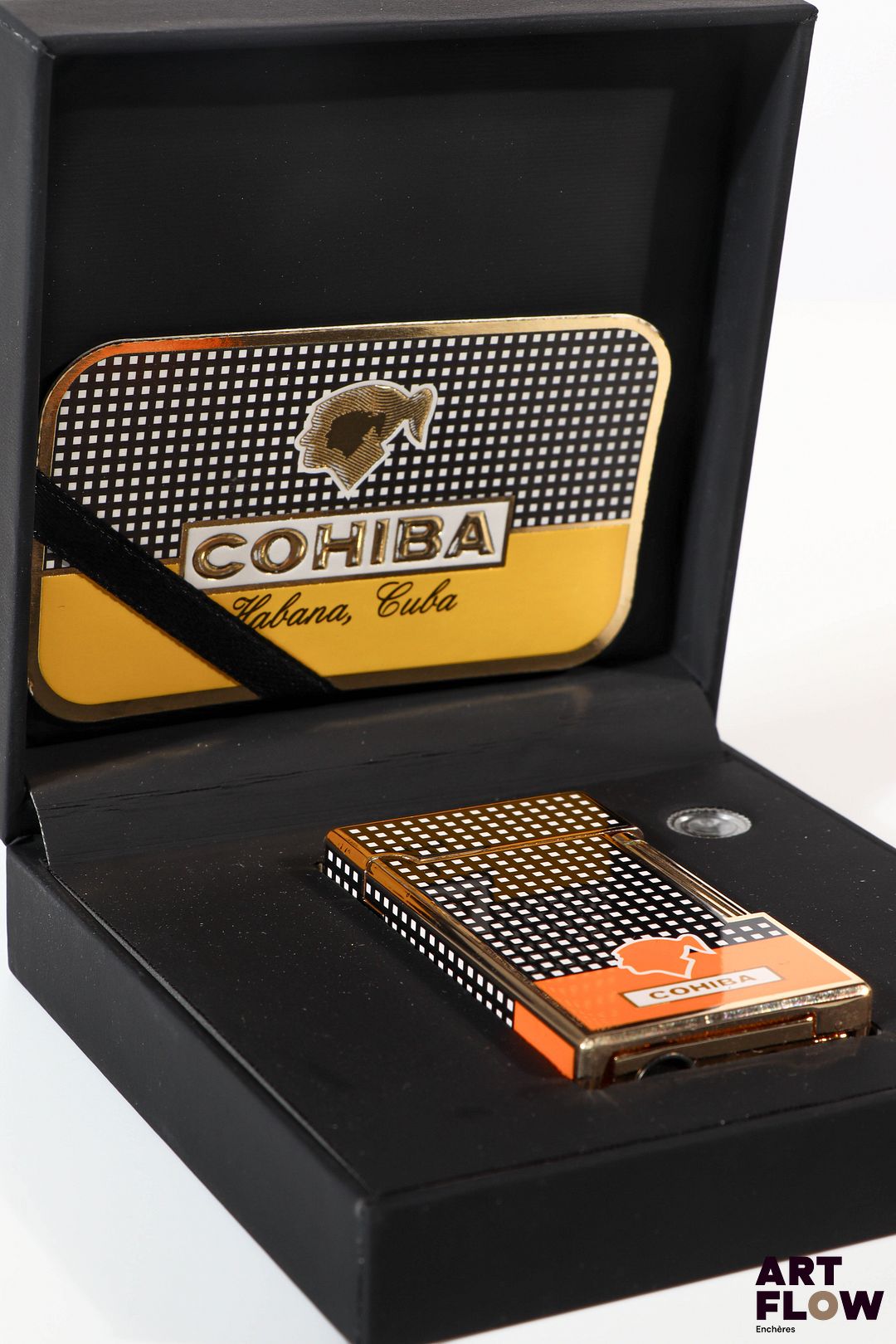 COHIBA Briquet en métal argenté laqué à décor géométrique noir et blanc Partie base du briquet de couleur orange 6,5 x 3,5 cm Dans son écrin Très bon état général