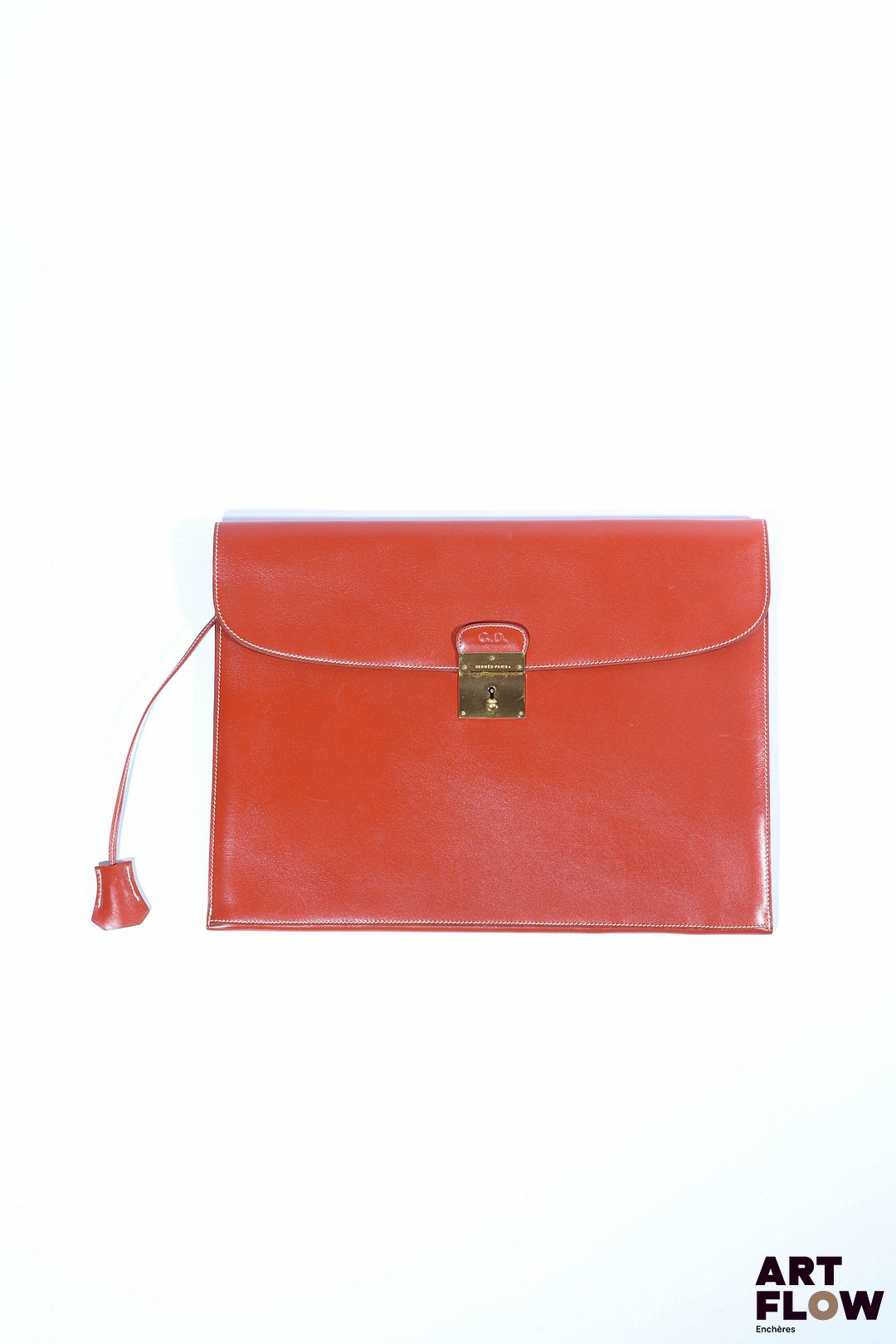 HERMÈS Modèle Jet Pochette porte-document en veau box brique, bijouterie en métal doré, et clés sous clochette. Signé, marqué « L’express » et chiffré à chaud : « C.D » Petites rayures et légères usures d’usage. Dim. : H. 28 x L.28 cm