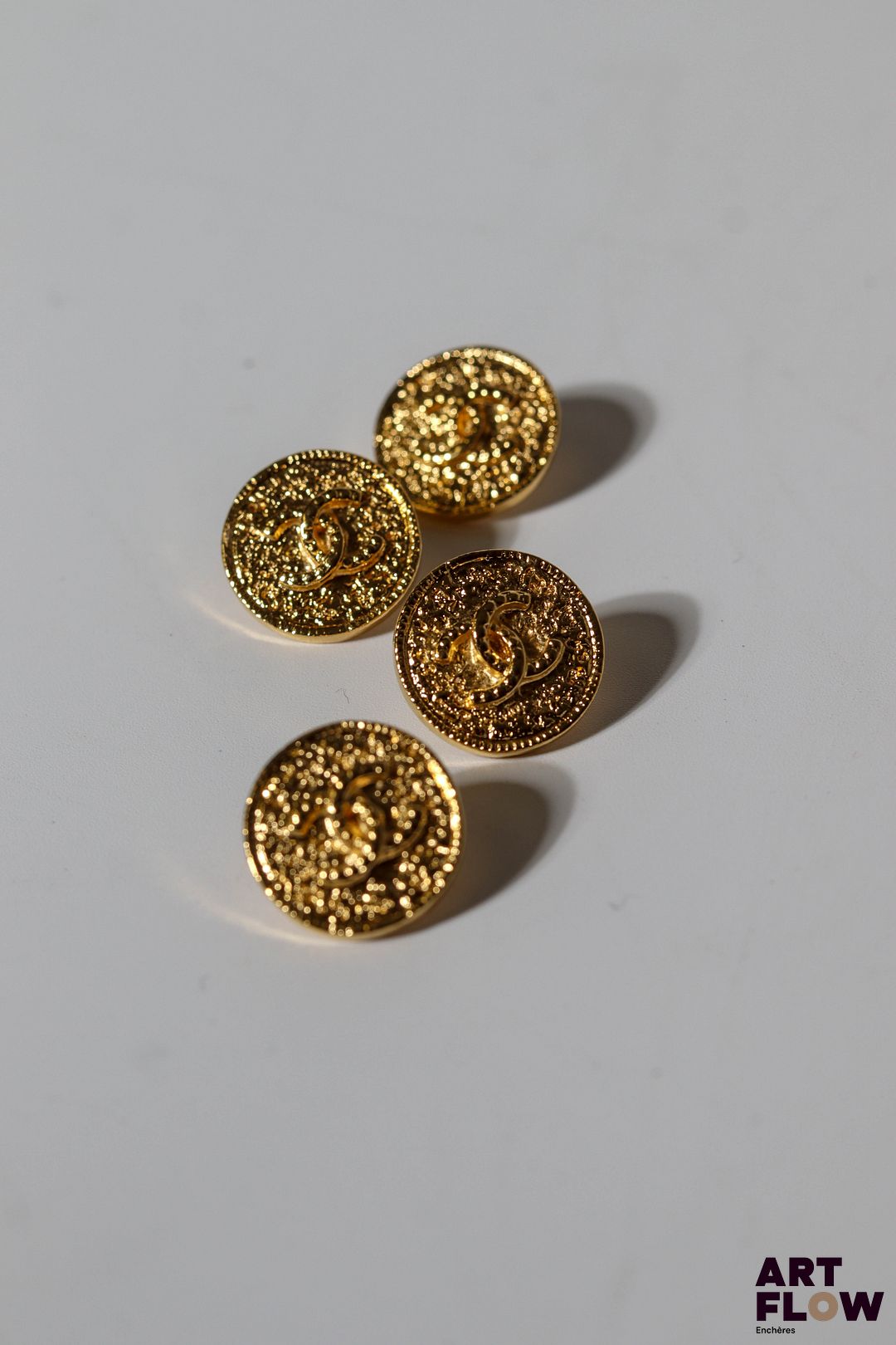 CHANEL Ensemble de quatre boutons en métal doré ornés du double C de Chanel. Diamètre : 1,7 cm