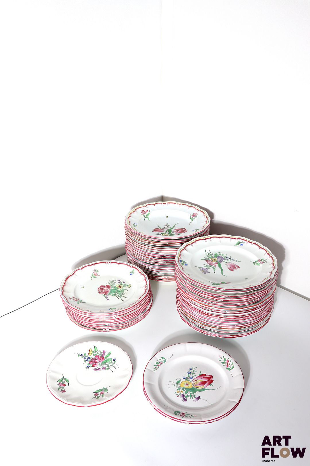 Keller & Guérin, Lunéville Partie de service en faïence émaillée polychrome à décor floral, comprenant : 48 assiettes plates 19 assiettes creuses 10 assiettes à dessert On y joint, d'un modèle similaire Trois soucoupes, deux pots à lait et une salière (accidents, ébréchures)