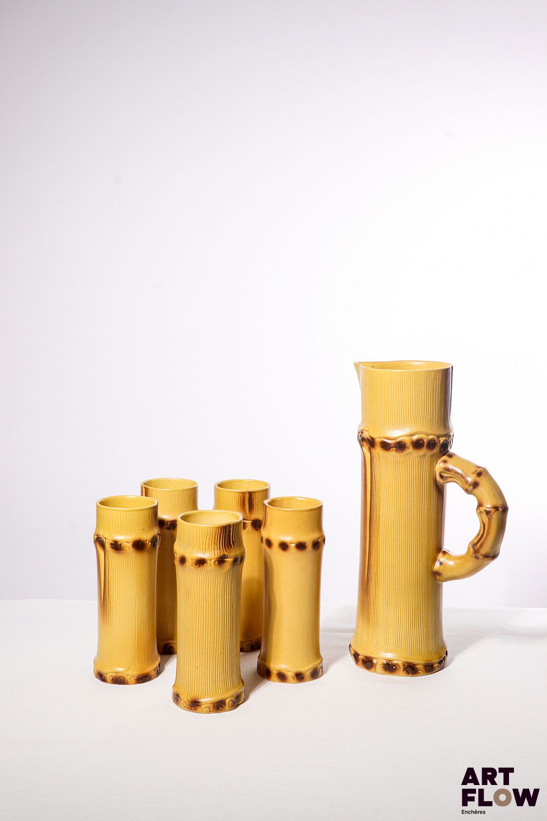 POL CHAMBOST (1906-1983) Service à orangeade 2002 "Bambou" en faience émaillée à décor polychrome naturaliste, comprenant un pichet et 5 verres. Le pichet incisé au revers "2002, Poterie Pol Chambost, Made in France, Déposé", et les verres "2003, Poterie Pol Chambost, Made in France" H. pichet 30,5 H. verres 17 cm Deux légers fêles à l'intérieur de l'un des verres Bibliographie : Philippe Chambost, "Pol Chambost, Sculpteur-Céramiste 1906-1983", Somogy Editions d'Art, Paris, 2006, modèle similaire p. 145