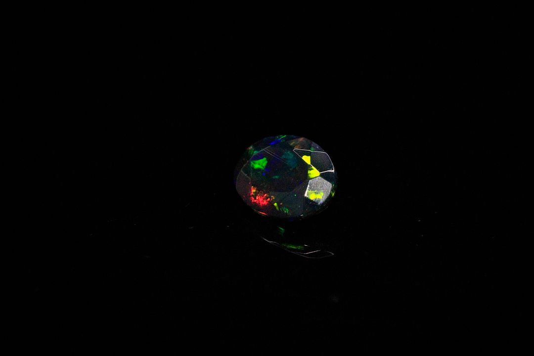Opale facettée noire ovale. Jolie couleur. 0.97 ct. 9.0mm x 7.0mm