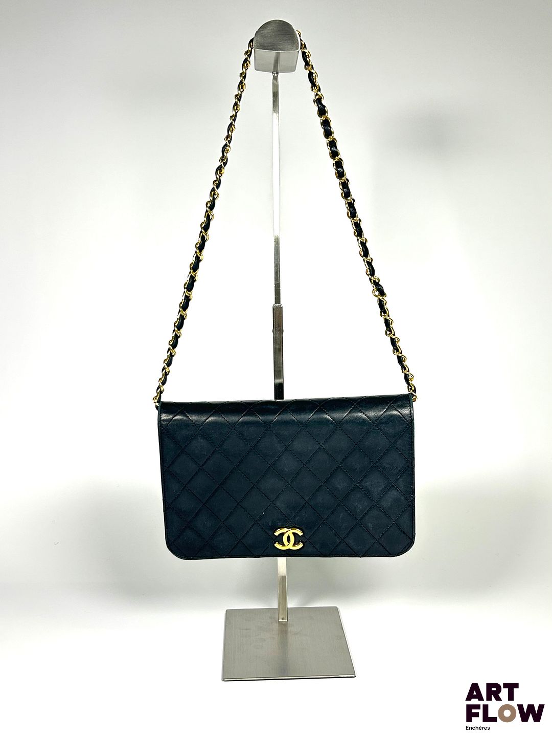 CHANEL Sac pochette en agneau matelassé noir, bijouterie en métal doré, fermeture par bouton pression, chaine escamotable. Circa 1980 Dimensions : H. 16 x L. 24 cm Dans sa boîte d'origine. Avec certification Entrupy