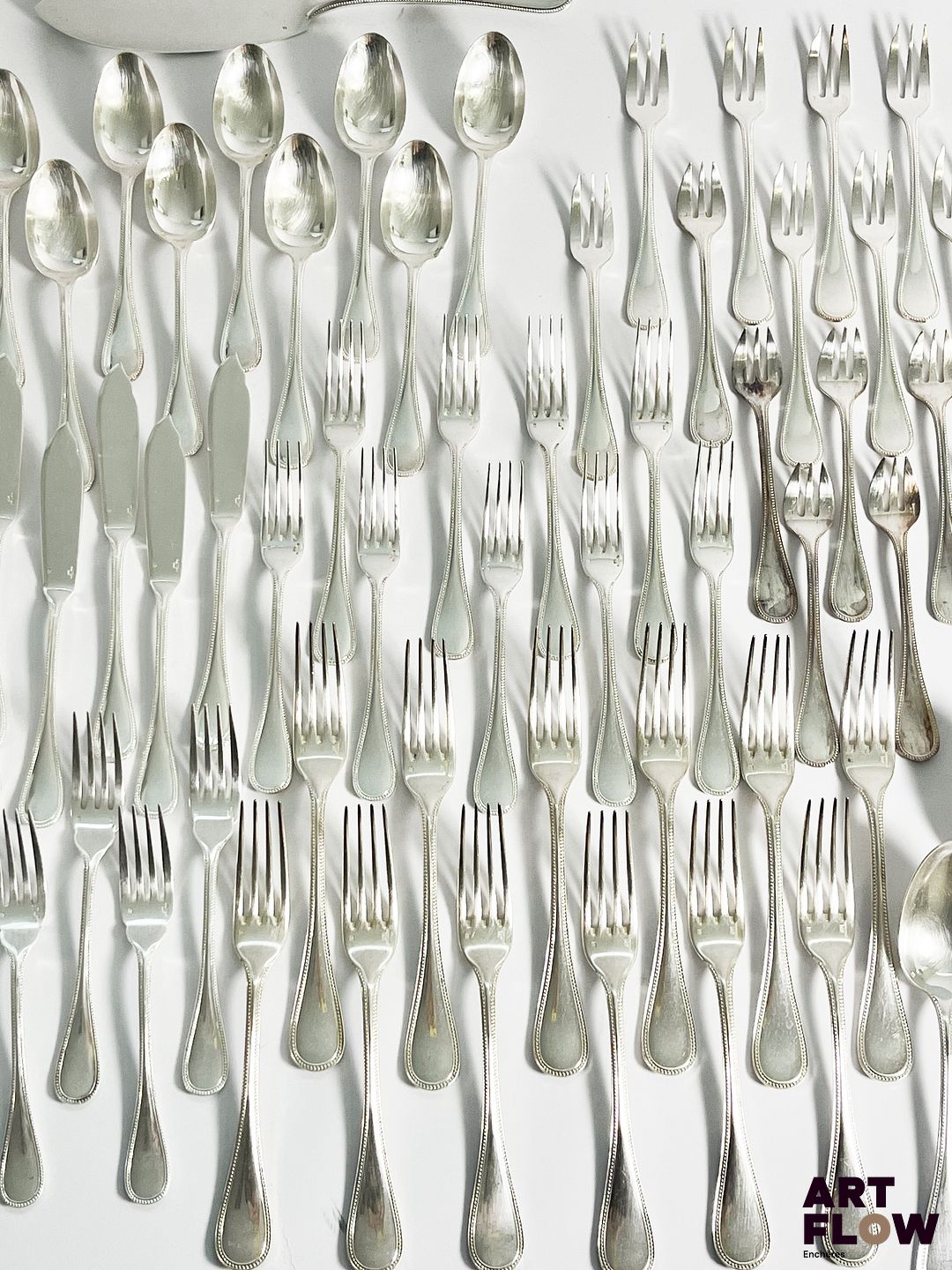 CHRISTOFLE Modèle Perles Partie de ménagère en métal argenté comprenant environ 114 pièces : - 12 couverts (12 fourchettes et 12 cuillères) - 12 couteaux - 10 fourchettes et 9 cuillères à entremet - 12 couteaux à entremets - 8 couverts à poisson - 8 fourchettes à huître - 8 fourchettes à dessert - 7 petites cuillères - 7 couverts de service - 1 couteau à fromages On y joint un lot de couverts Christofle rapportés d'un modèle différent