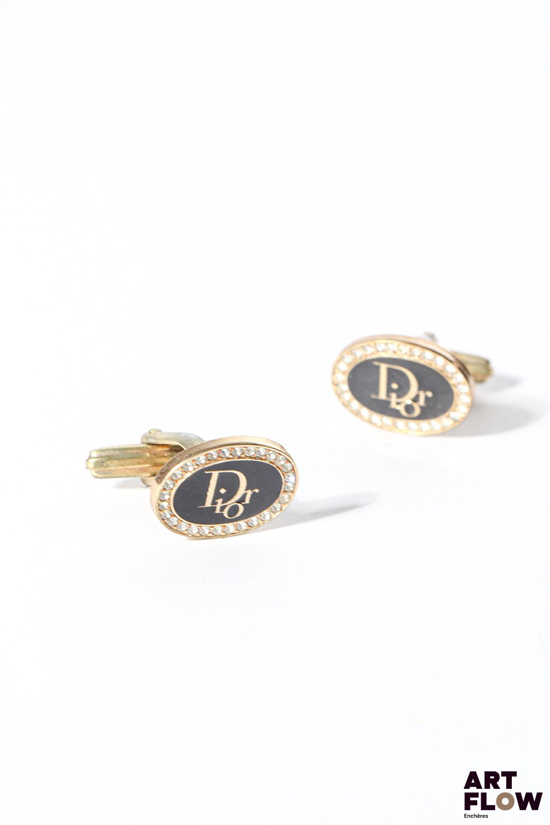 CHRISTIAN DIOR Boutons de manchette en métal doré monogrammés et sertis de strass Dimensions : 1,3 x 1,8 cm Fournie avec son écrin d'origine