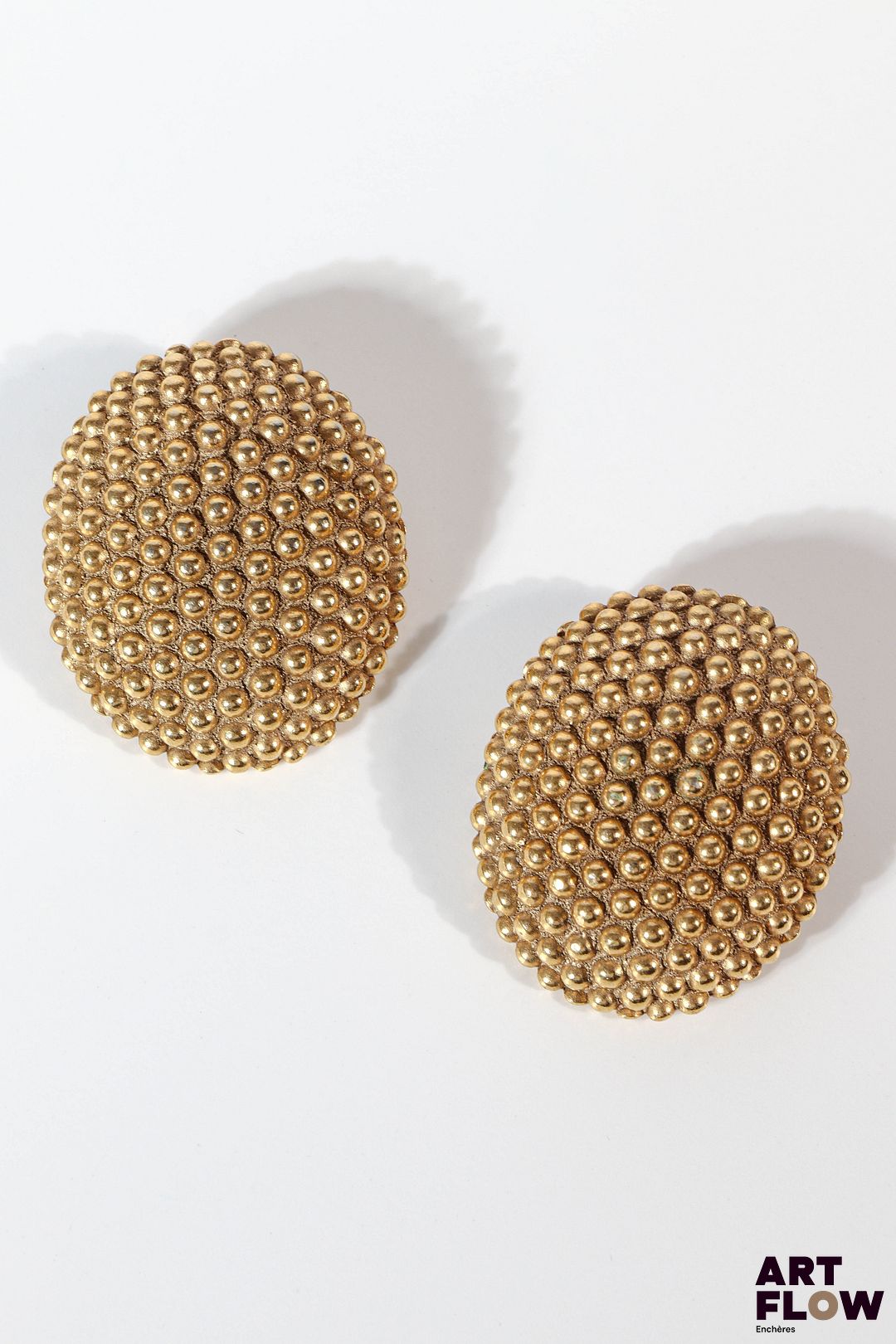 YVES SAINT LAURENT Paire de boucles d'oreilles en métal doré grainé Signées. Dim. 4,5 x 3,5 cm
