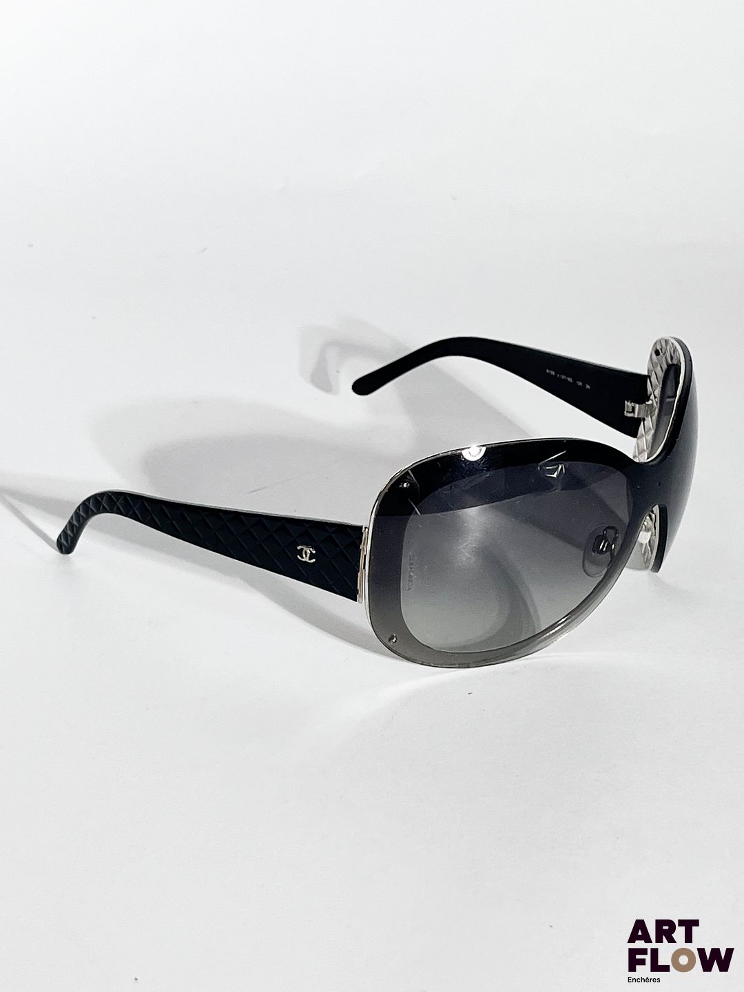 CHANEL Lunettes de soleil noires, motif matelassé sur les branches. Dimensions : H. 6 x L. 17 cm
